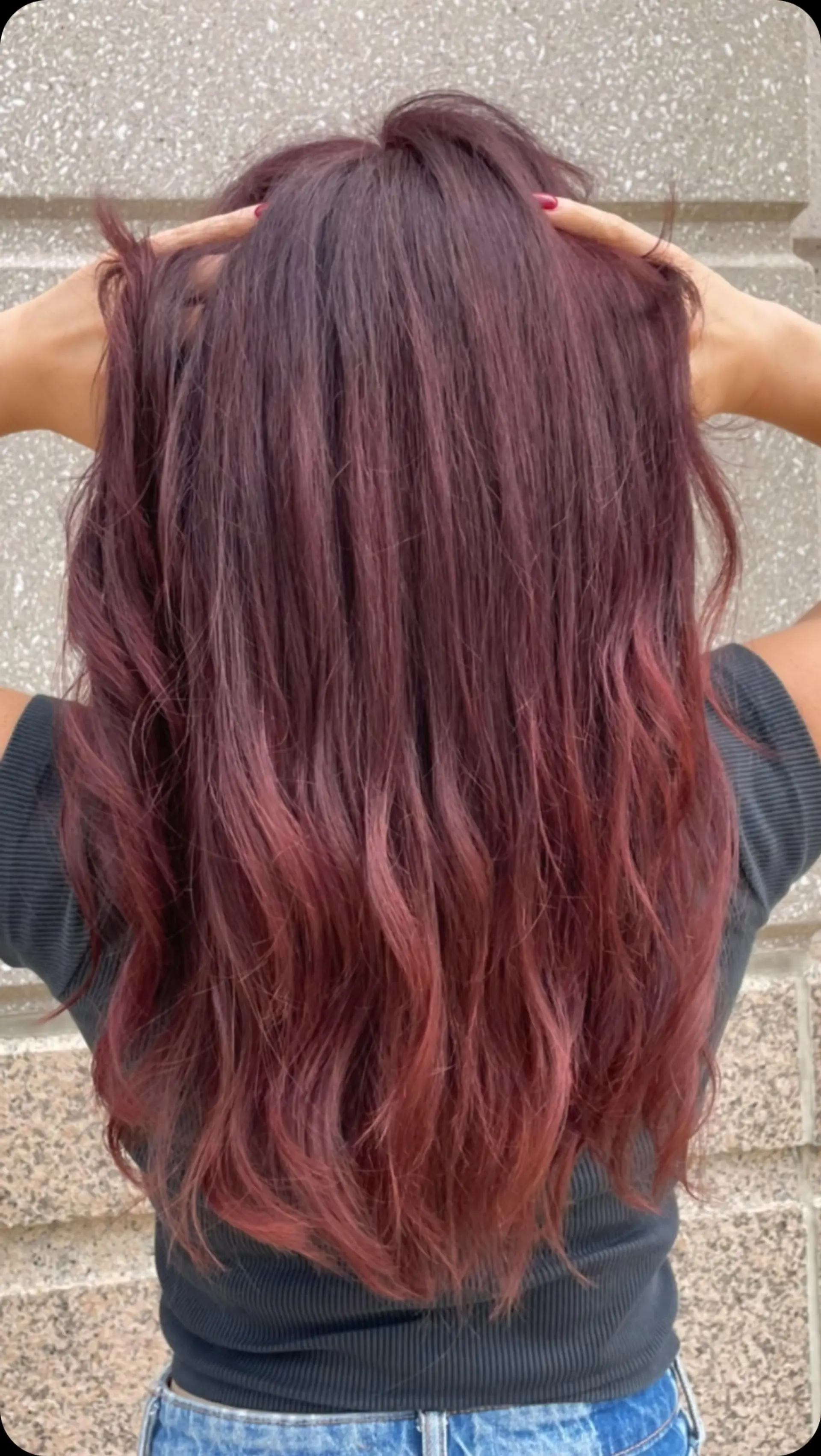 Long wavy hair featuring a seamless color melt transitioning from deep burgundy roots into lighter crimson red ends. 1