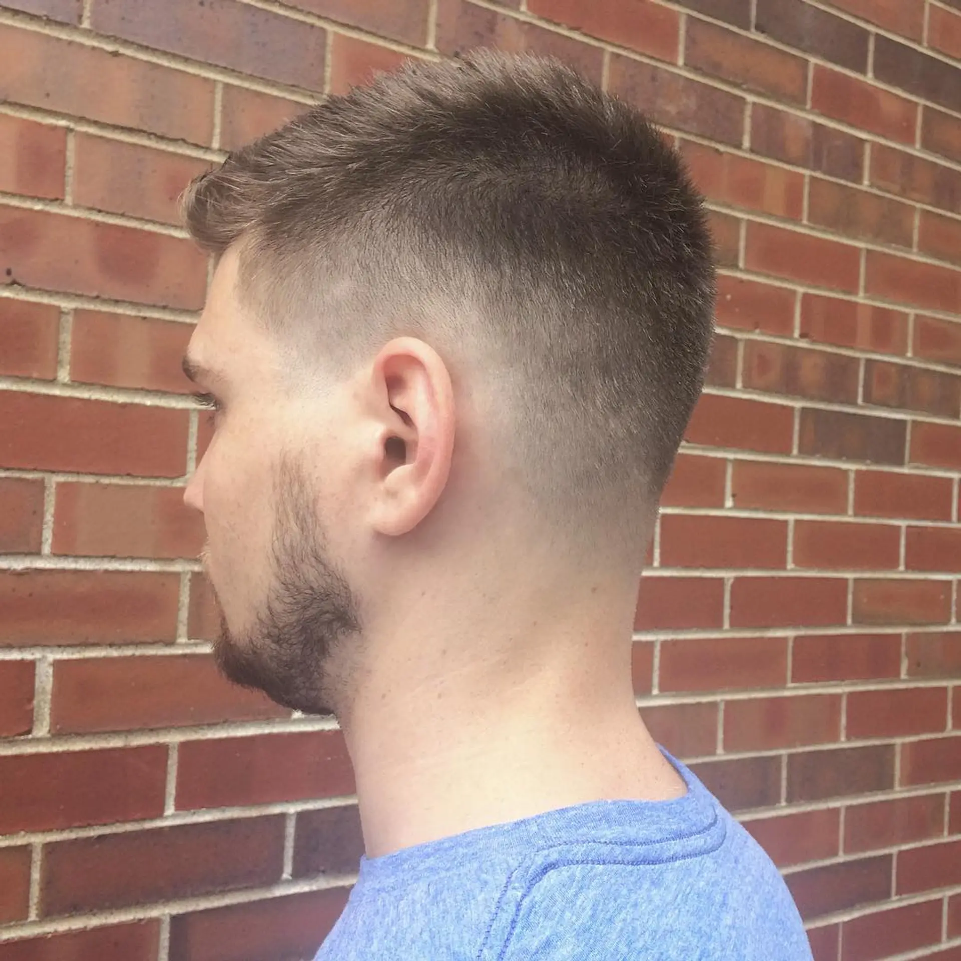 A timeless taper fade featuring short, textured hair on top. 1