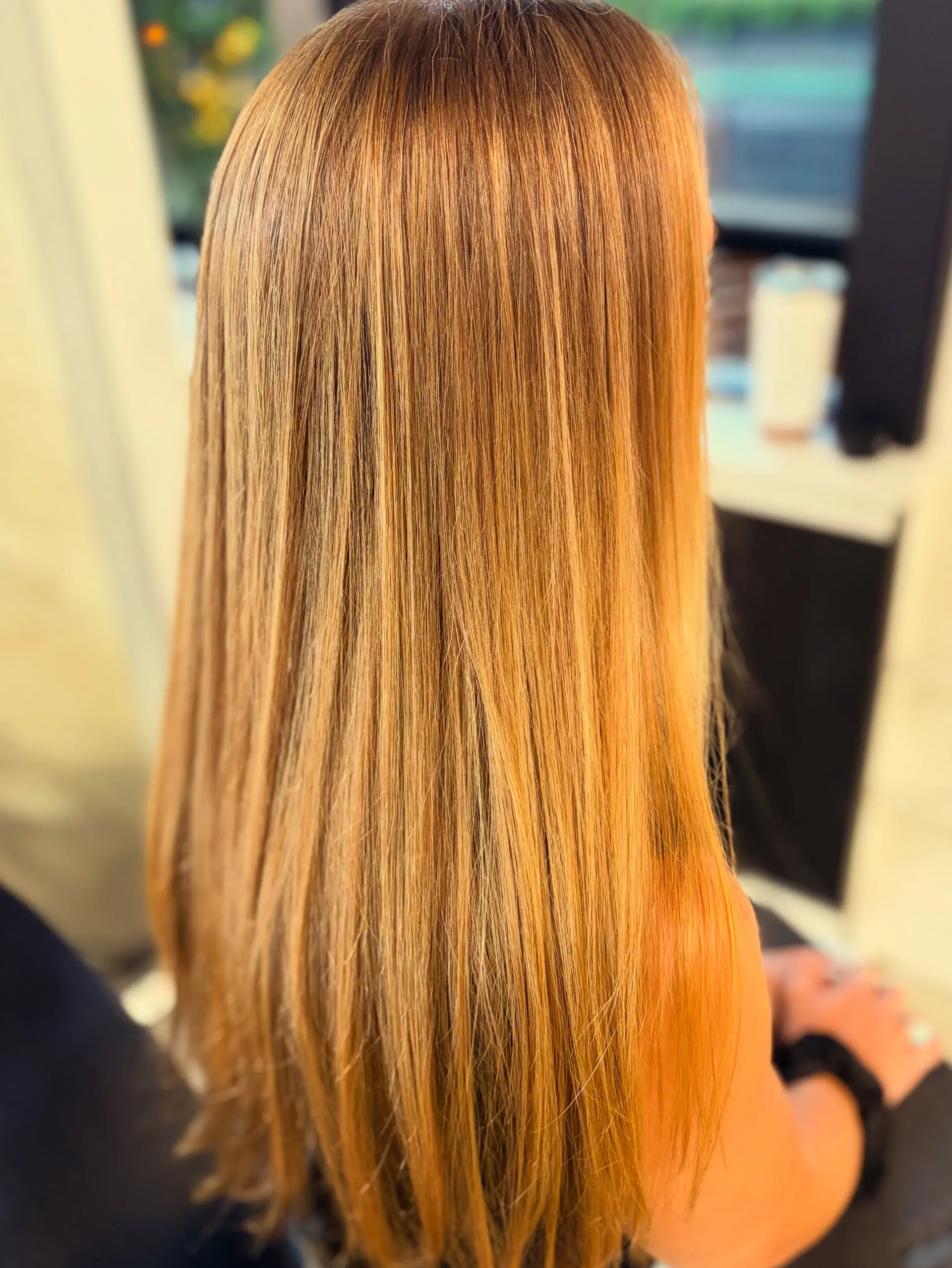 Long straight hair in a warm honey and strawberry blonde shade, styled sleek and smooth. 1