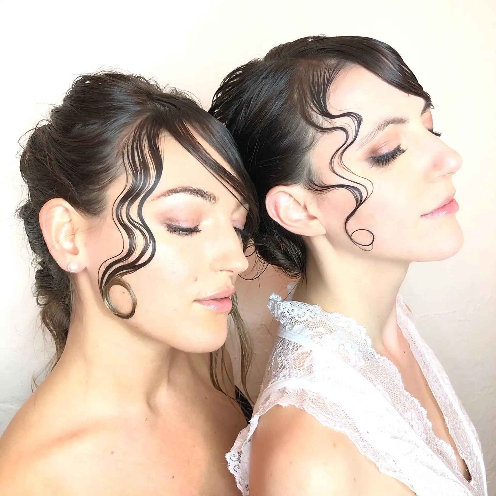 Elegant editorial updo featuring sleek, gel-sculpted wave tendrils framing the face. 1