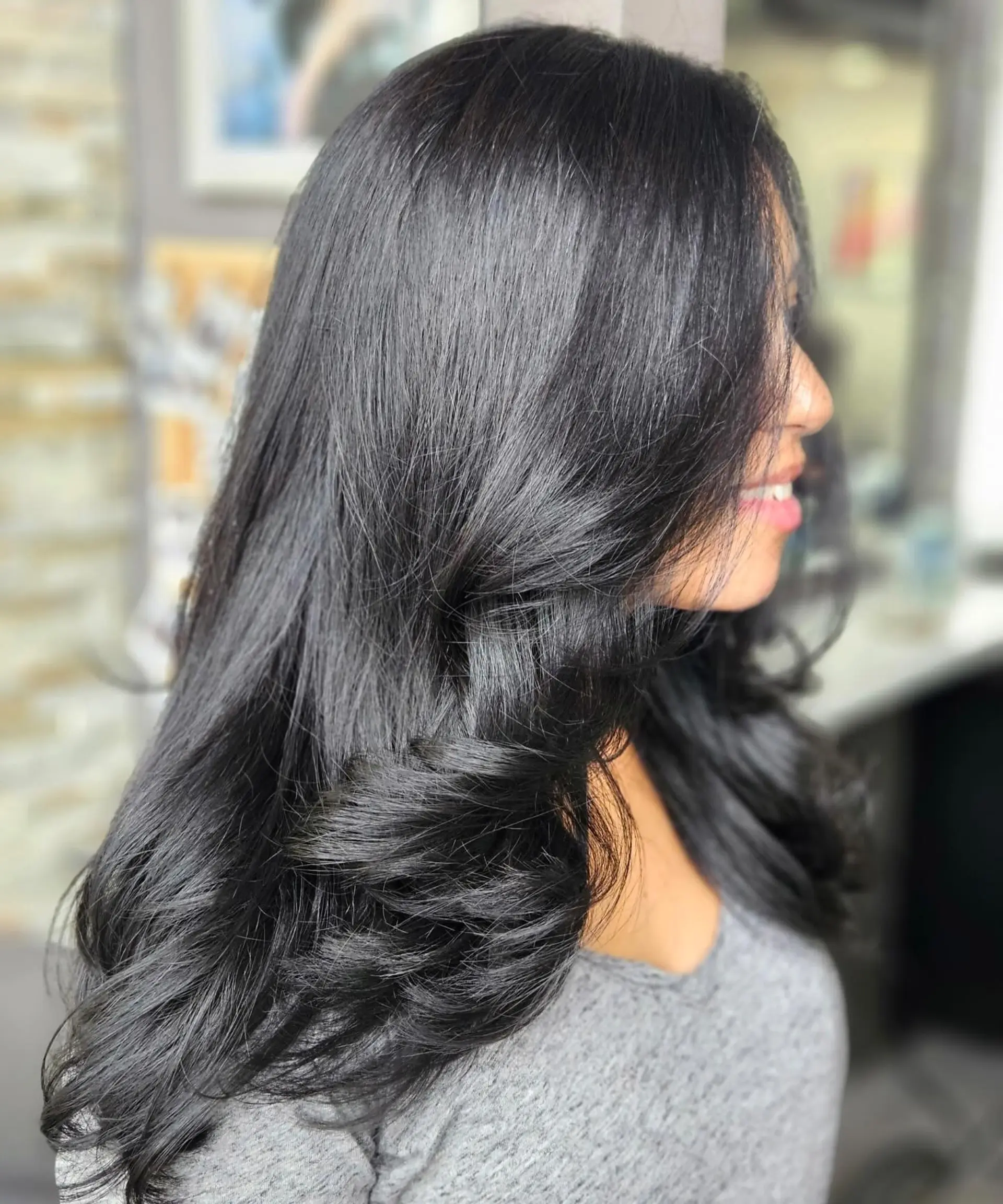 Long, glossy black hair cut in cascading layers with polished, bouncy curved ends. 1