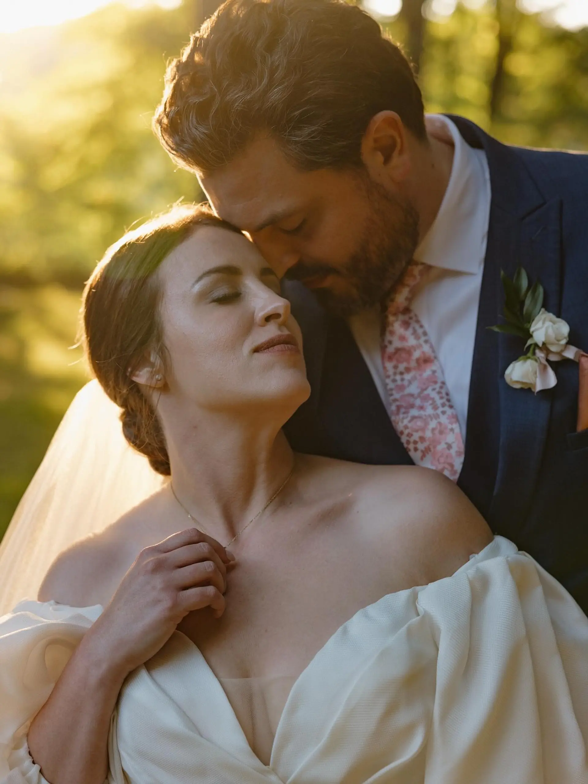 A sleek, classic bridal low updo styled back smoothly and accessorized with a wedding veil. 1