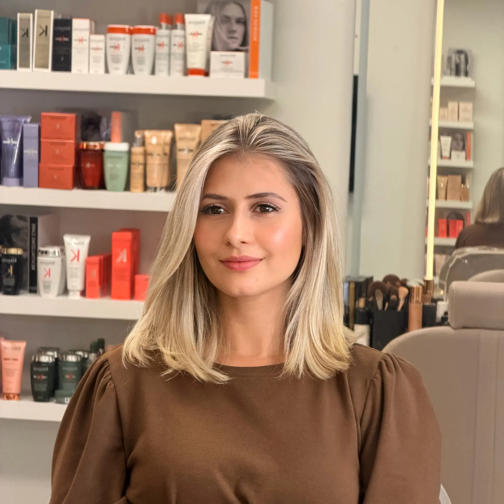 Medium-length blonde lob styled with a smooth, voluminous blowout and subtle bend at the ends. 1