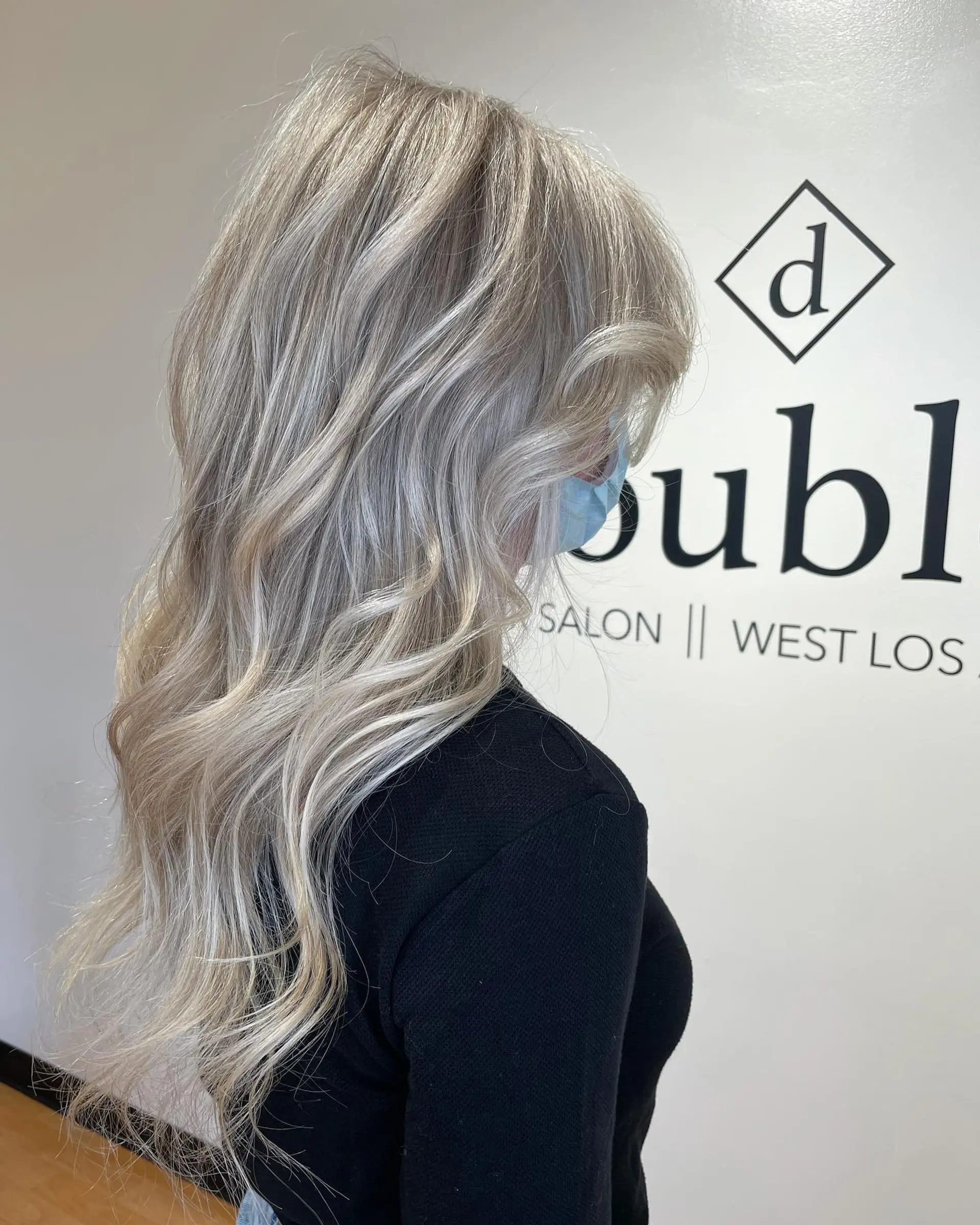 Long cool ash blonde hair with seamless gray blending highlights, styled into soft, elegant waves. 1