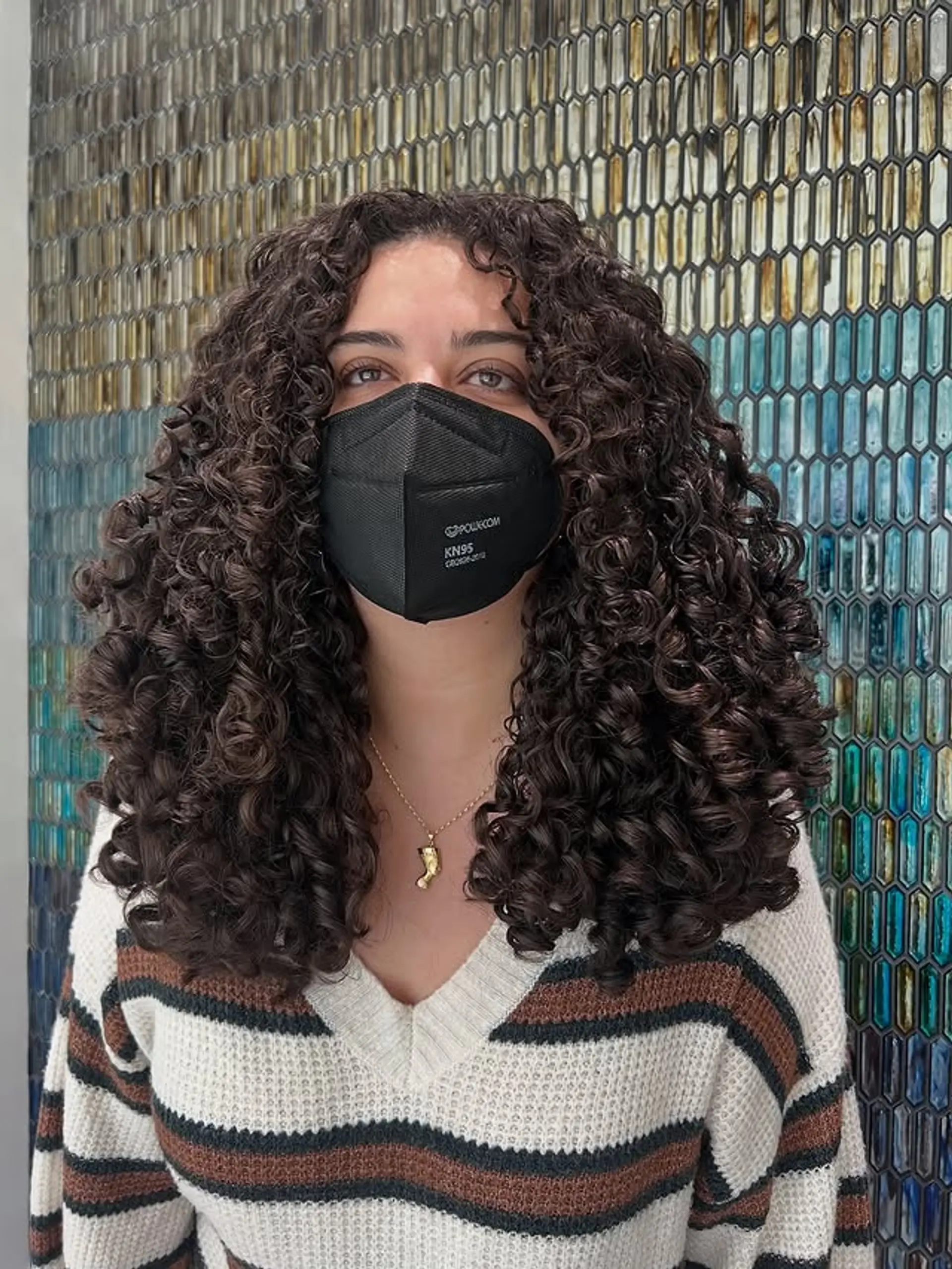 A long, layered curly haircut designed to enhance natural curl definition and volume. 1