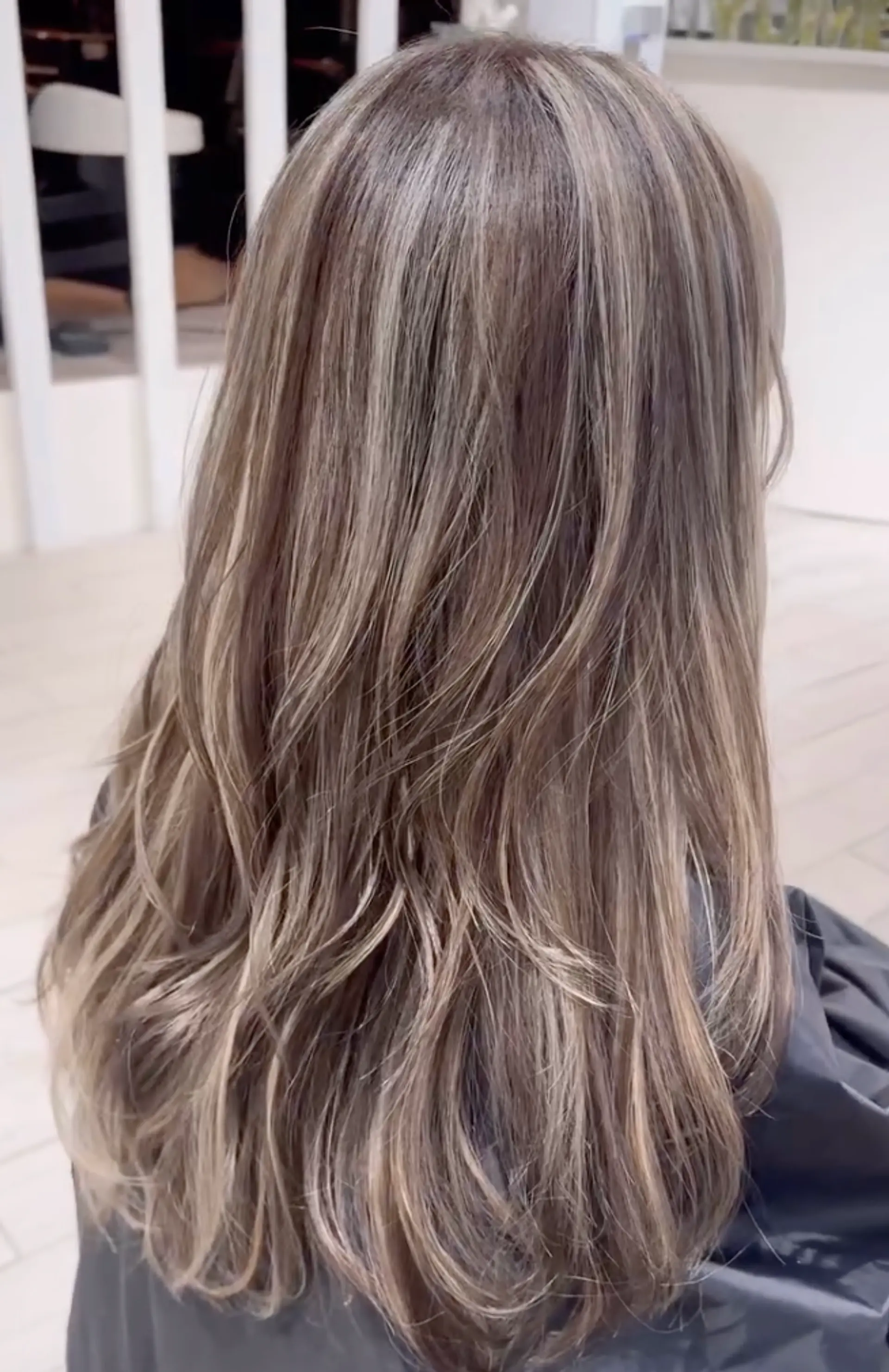 Long, wavy locks with ash blonde base and multi-dimensional platinum highlights, featuring natural waves and cool tones. 1