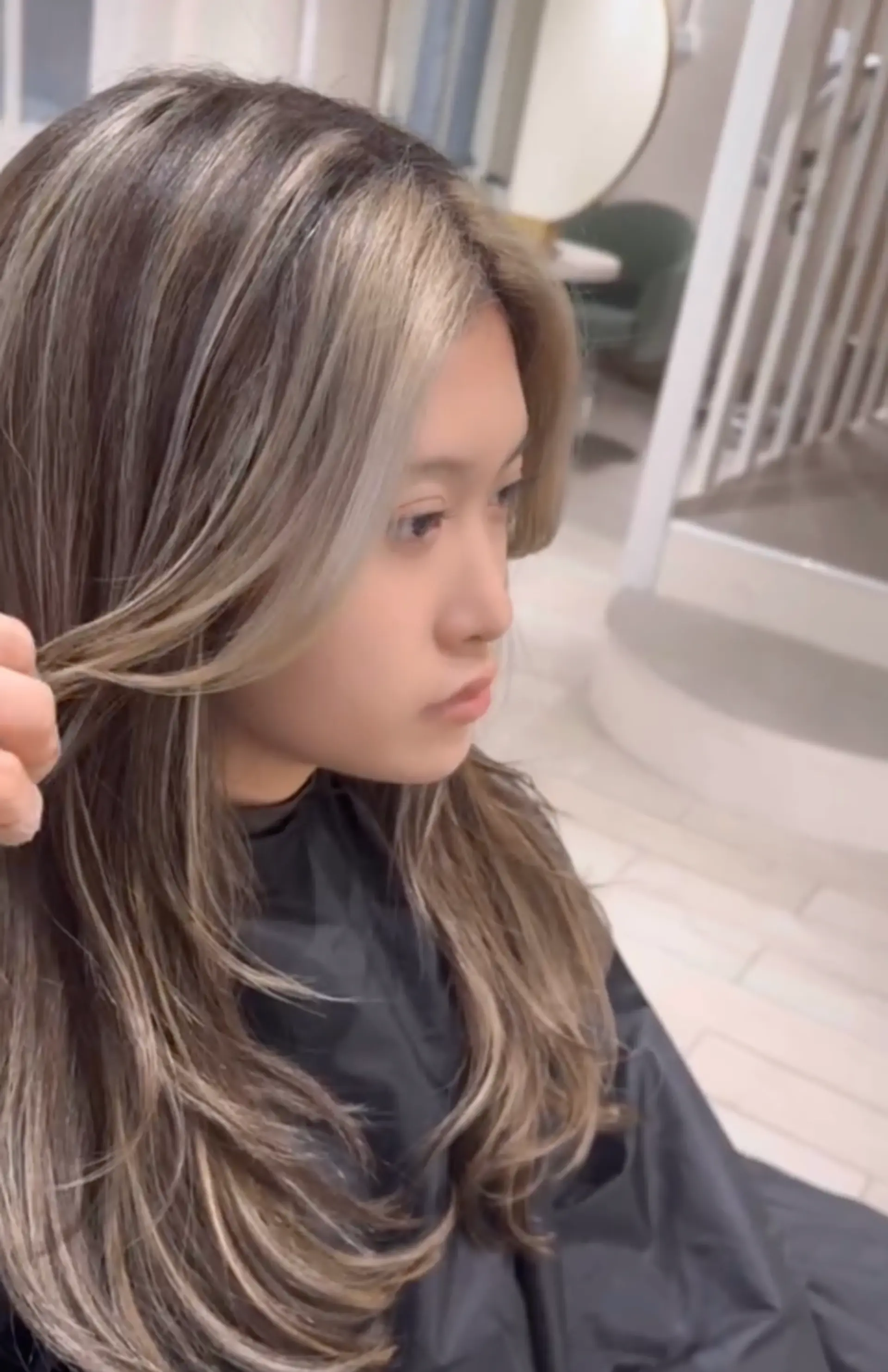 Long, wavy locks with ash blonde base and multi-dimensional platinum highlights, featuring natural waves and cool tones. 2