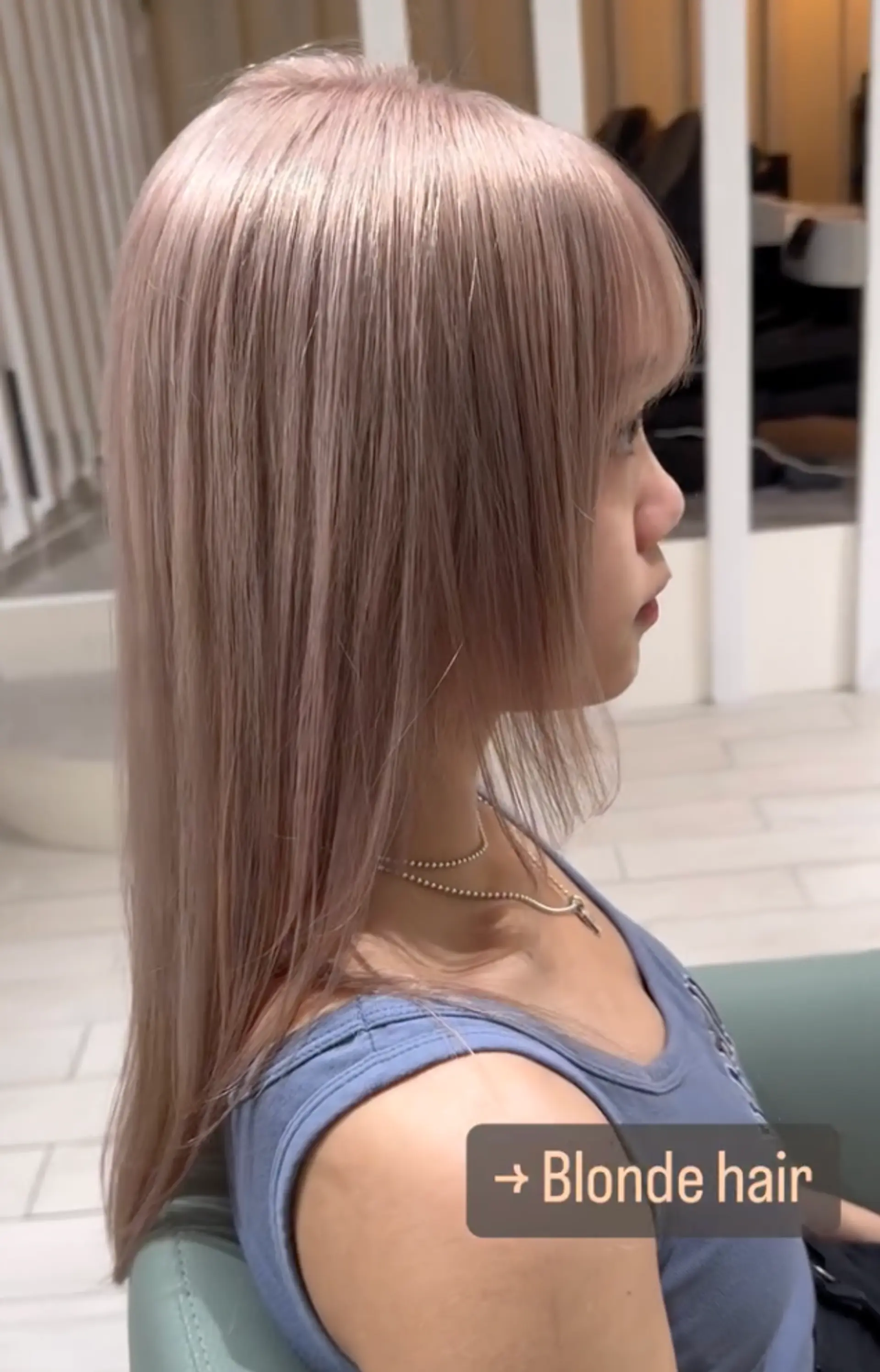 A stunning long, straight, platinum blonde hairstyle with blunt bangs and a smooth, layered finish. 1