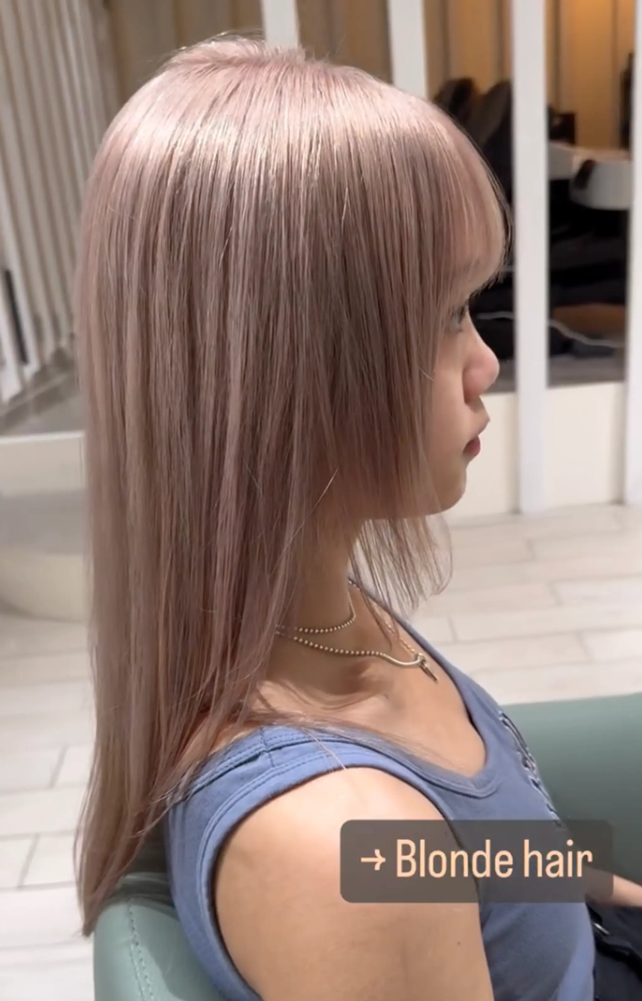 A stunning long, straight, platinum blonde hairstyle with blunt bangs and a smooth, layered finish.