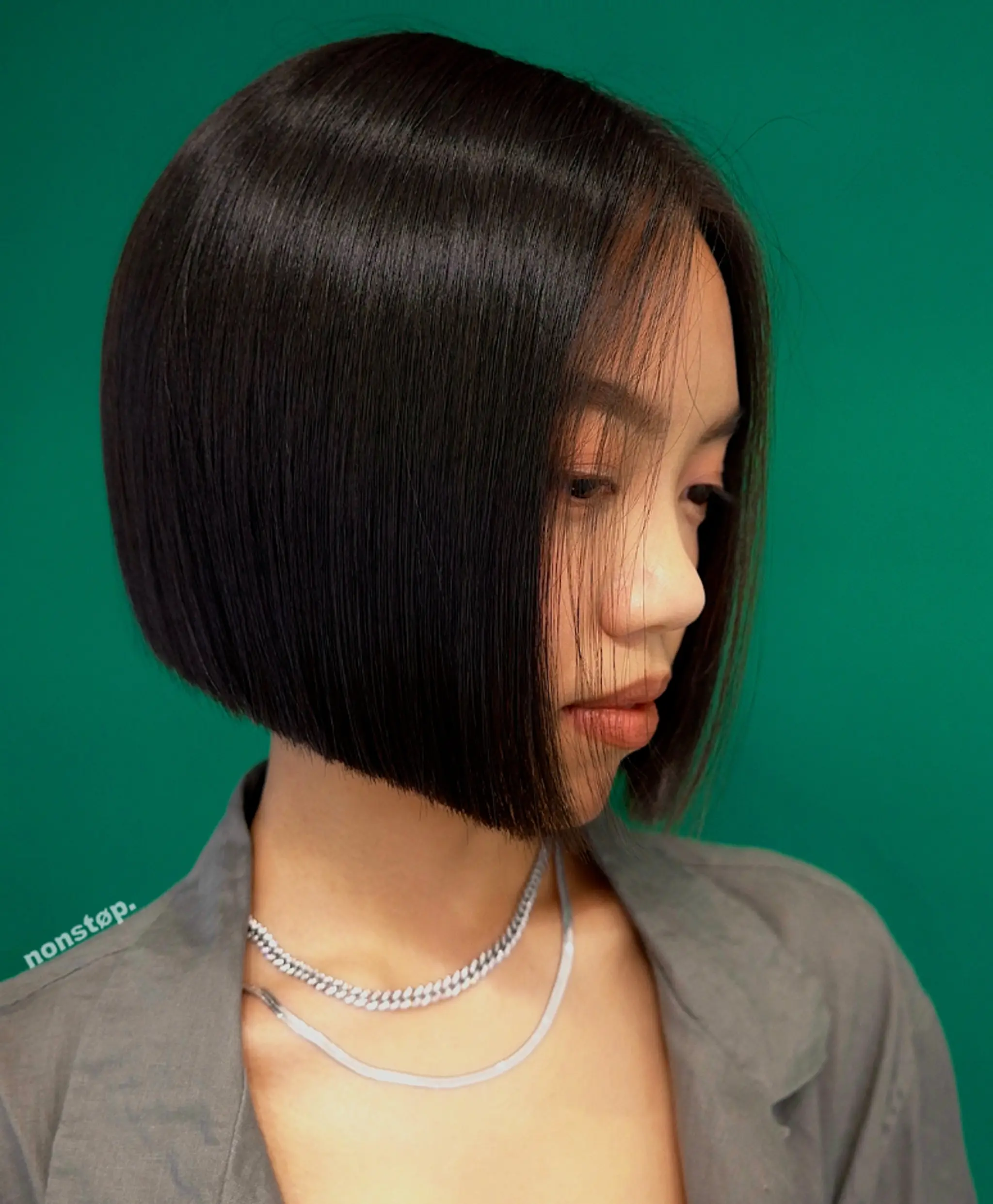 This sleek, straight bob is a polished and modern style featuring blunt ends and an angular cut that beautifully frames the face. The hair is perfectly straight, short in length, and showcases a rich black color, giving it an edgy yet sophisticated look. The hair falls effortlessly, highlighting the minimalist yet chic nature of the cut. 1