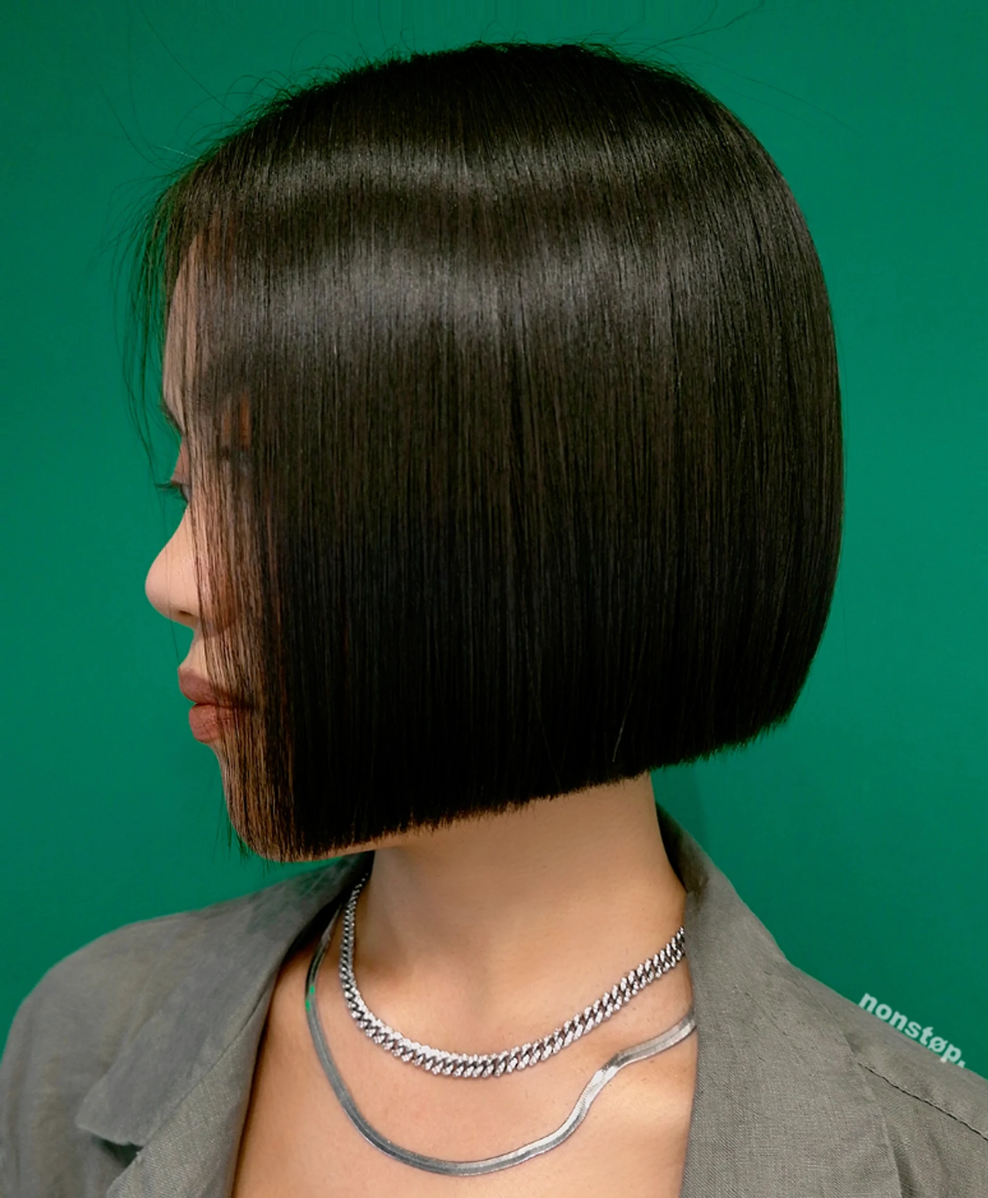 A model with a perfectly sleek, modern blunt-cut bob, showcasing a key 2025 hair trend. - Preview 2