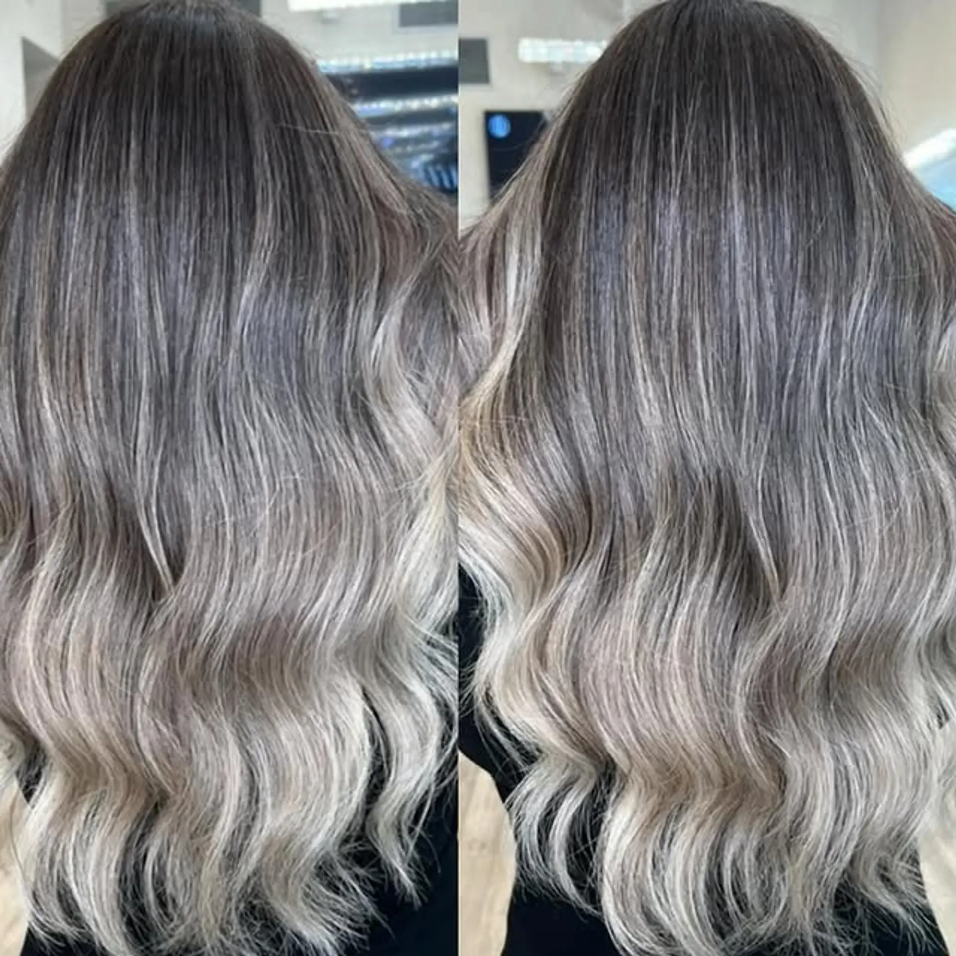 A long wavy hairstyle with dark roots blending into icy blonde. 1