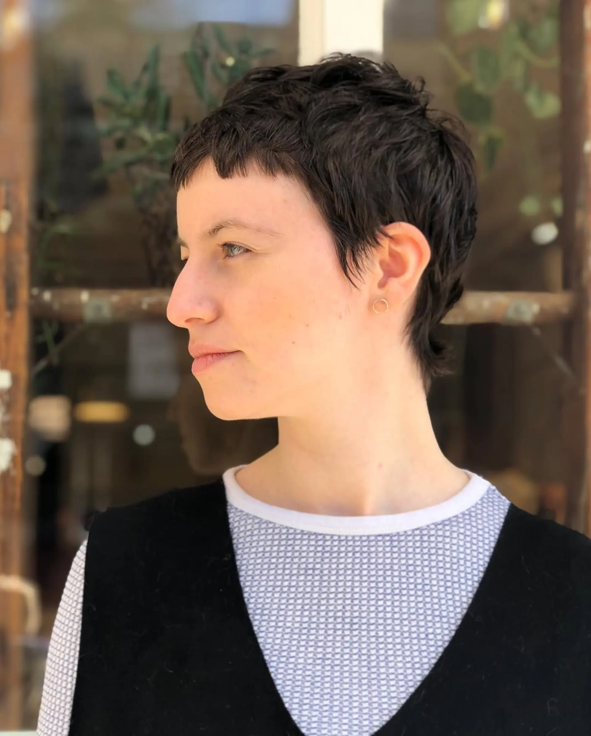 Short, dark brown pixie cut with short layers, textured ends, and a cropped fringe. 1