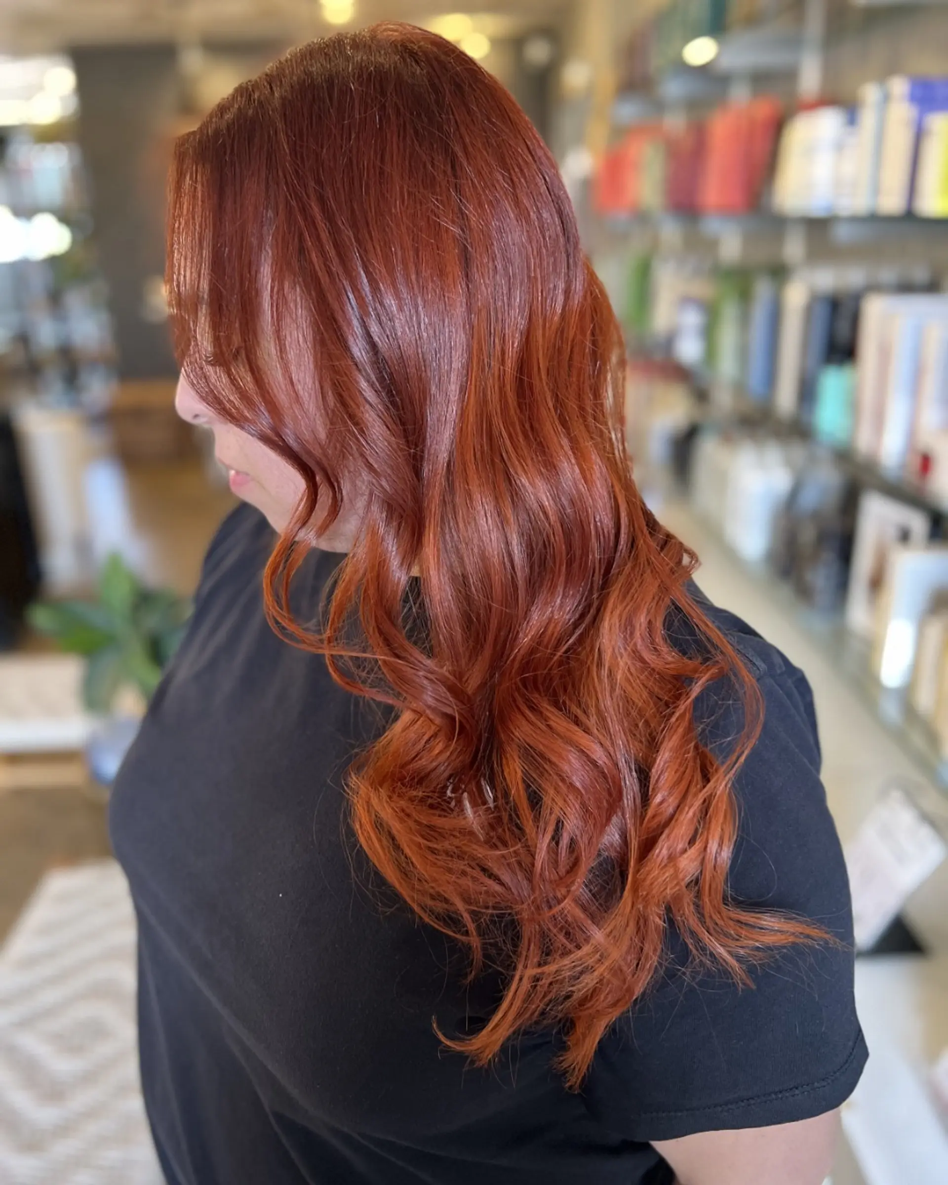 Rich auburn and warm copper balayage with deeper roots, styled in soft, glossy waves cascading past the shoulders. 1