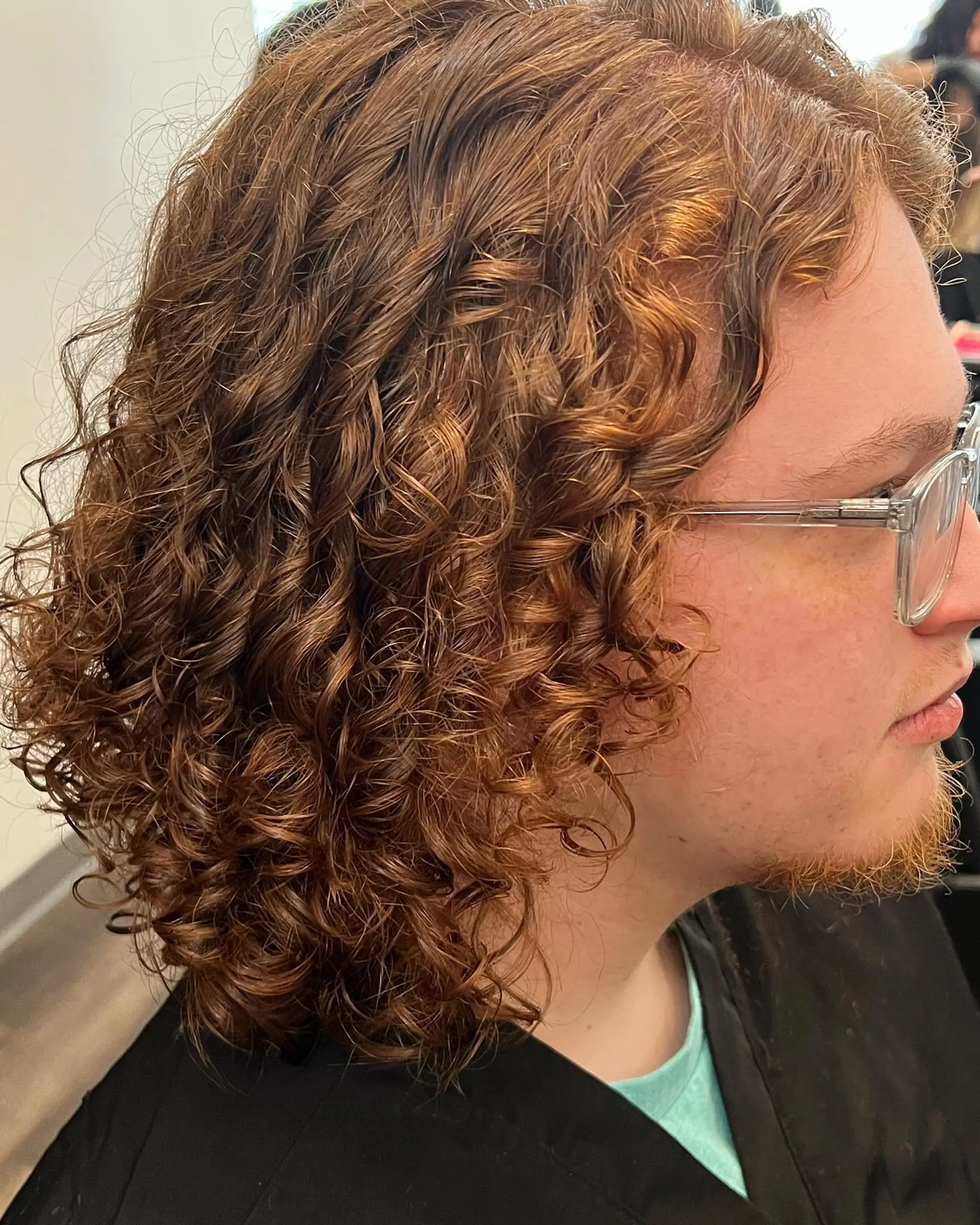 Shoulder-length natural curls with high shine, bounce, and defined texture in a rich copper-auburn tone. 1