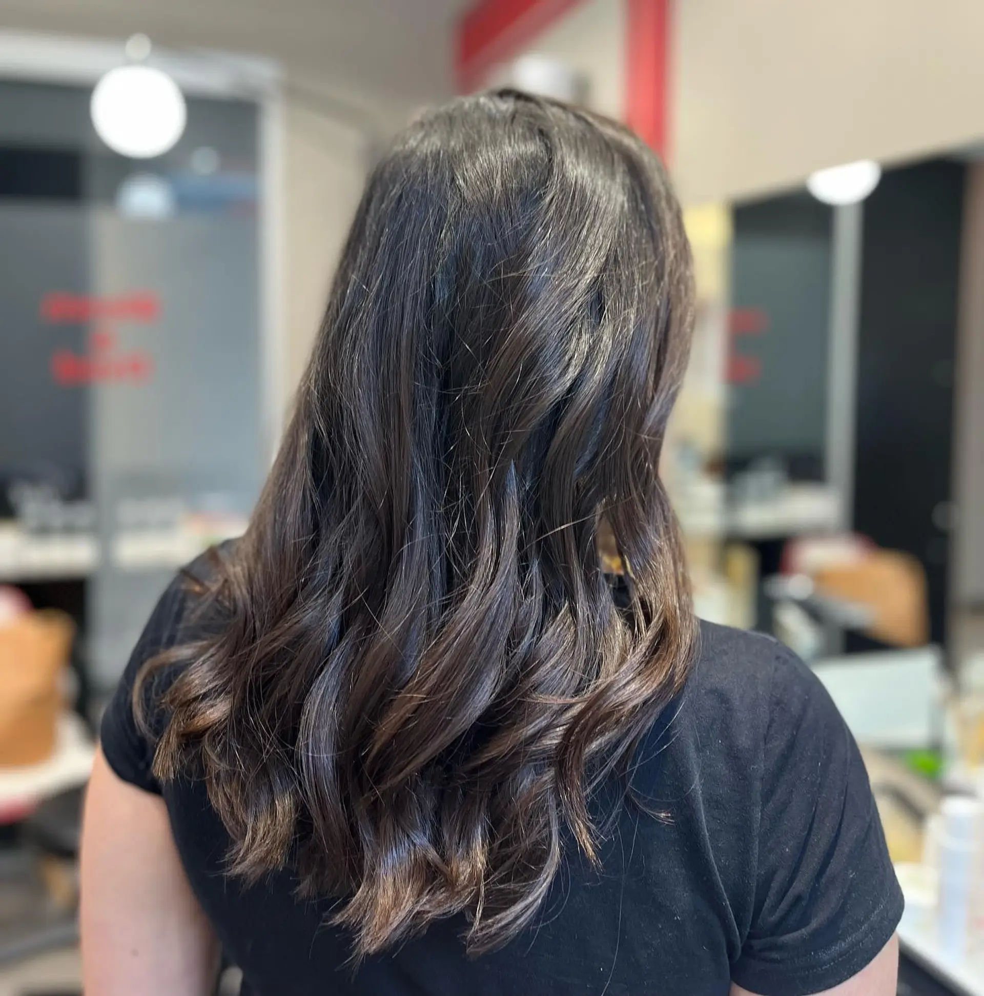 A medium-length wavy hairstyle with a soft, blended chocolate swirl balayage. 1