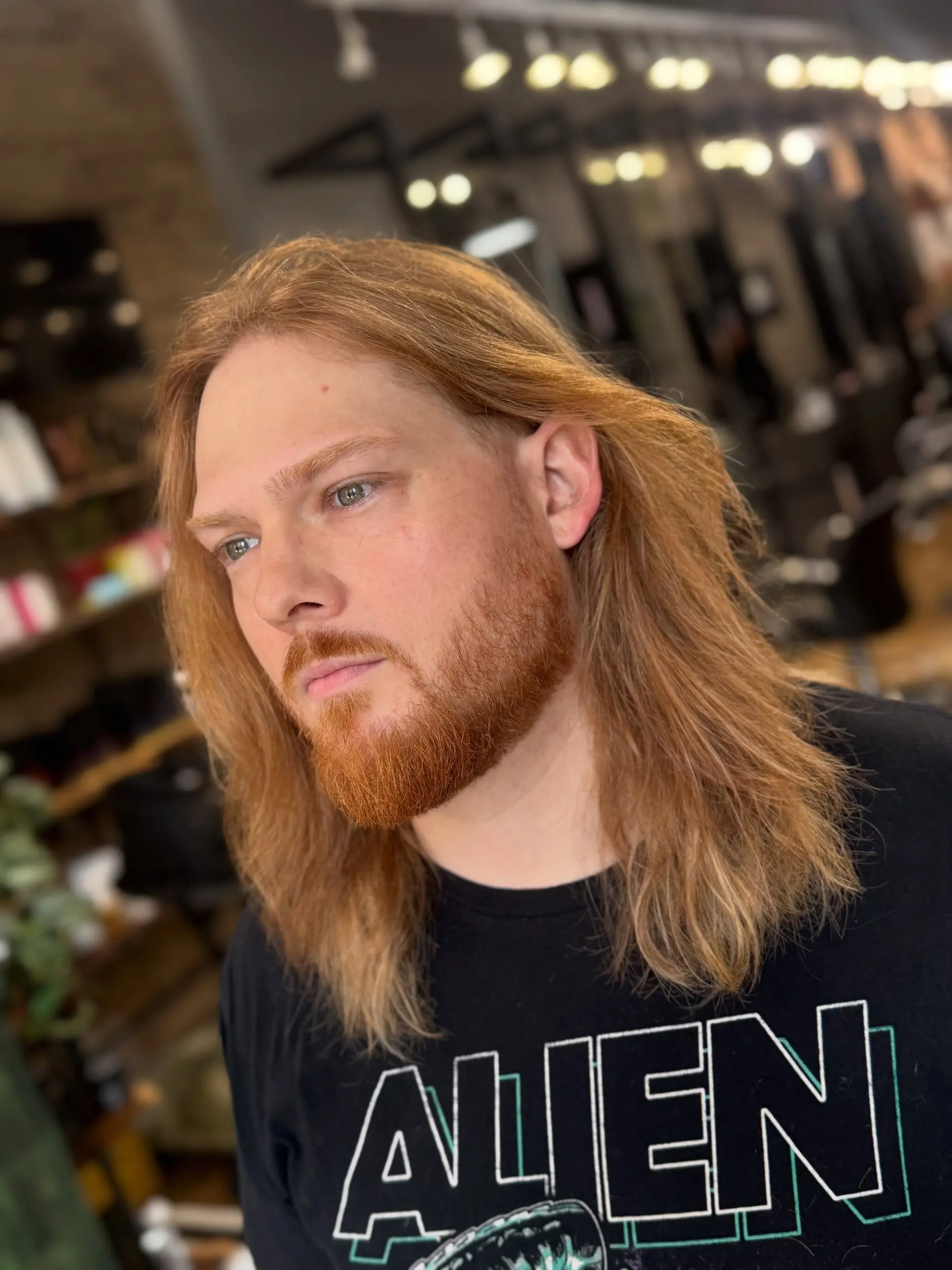 Shoulder-length textured copper hair swept back naturally, paired with a clean, groomed beard. 1