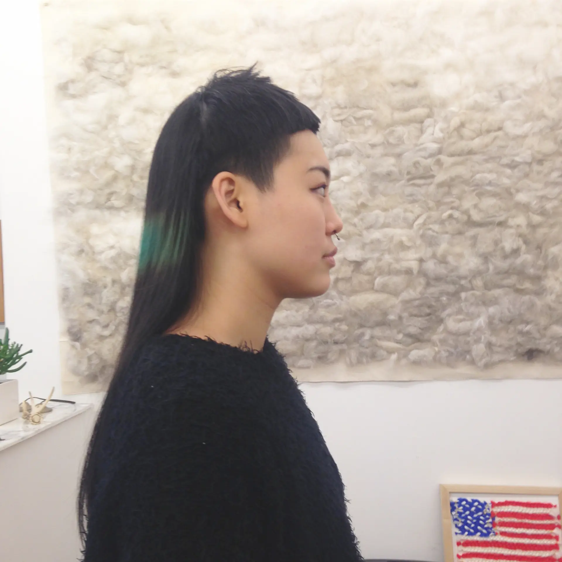 An eye-catching modern hairstyle featuring a stark undercut that contrasts with longer straight black hair. The top section is styled into an edgy, angular fringe, blending seamlessly into longer layers that descend past the shoulders. Green line💚🤑🌵 2