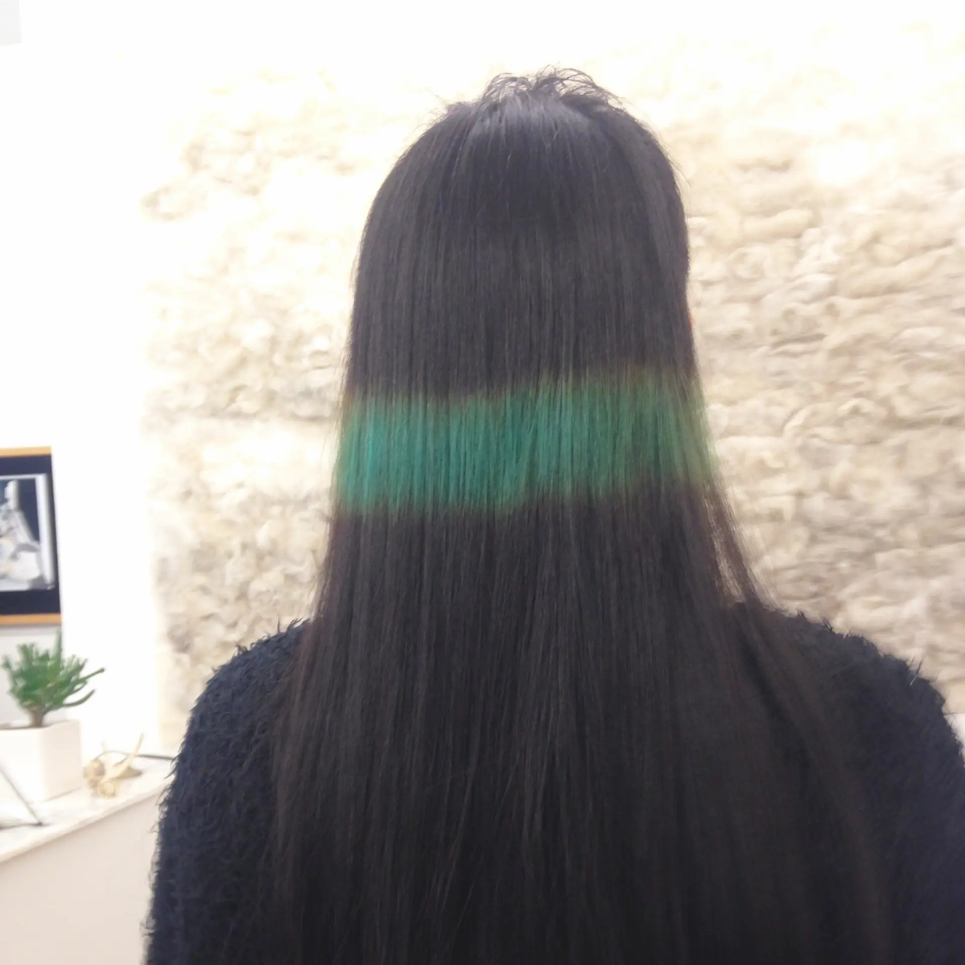 An eye-catching modern hairstyle featuring a stark undercut that contrasts with longer straight black hair. The top section is styled into an edgy, angular fringe, blending seamlessly into longer layers that descend past the shoulders. Green line💚🤑🌵 3