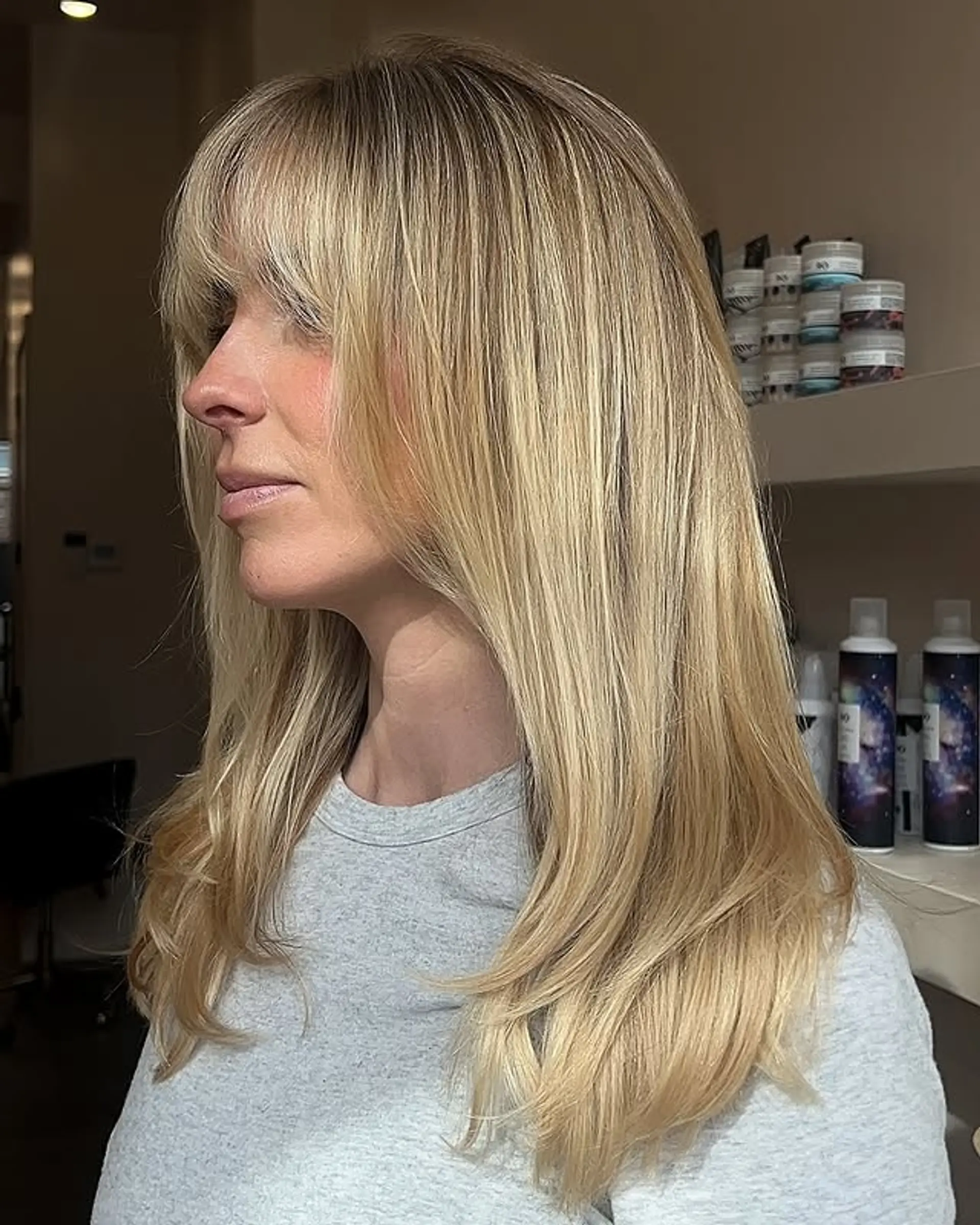 A long, layered hairstyle with face-framing layers and bardot bangs. 1