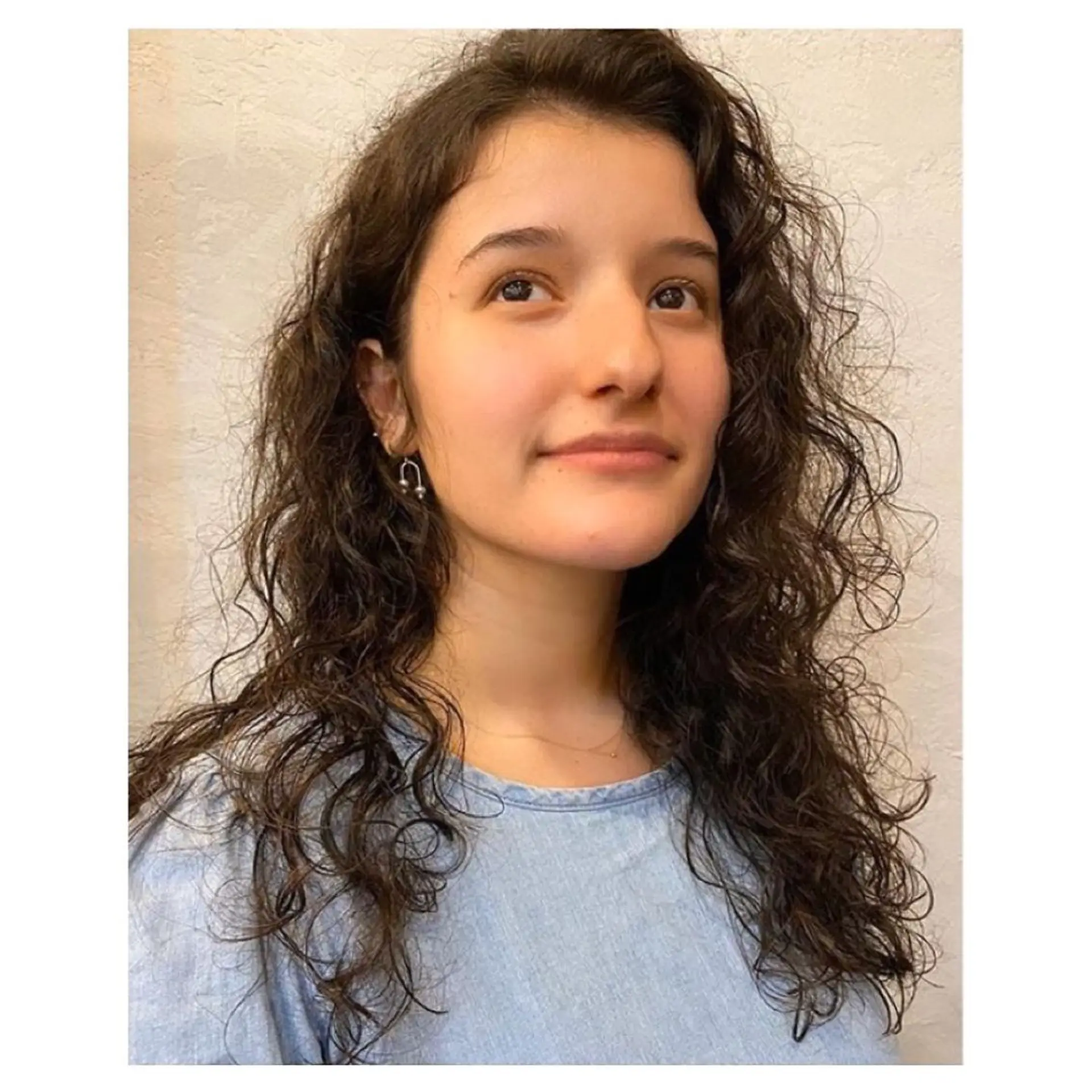 Medium-length curly hair with natural texture. The dark brown curls are voluminous and layered, cascading down to frame the face softly by Coco. 1