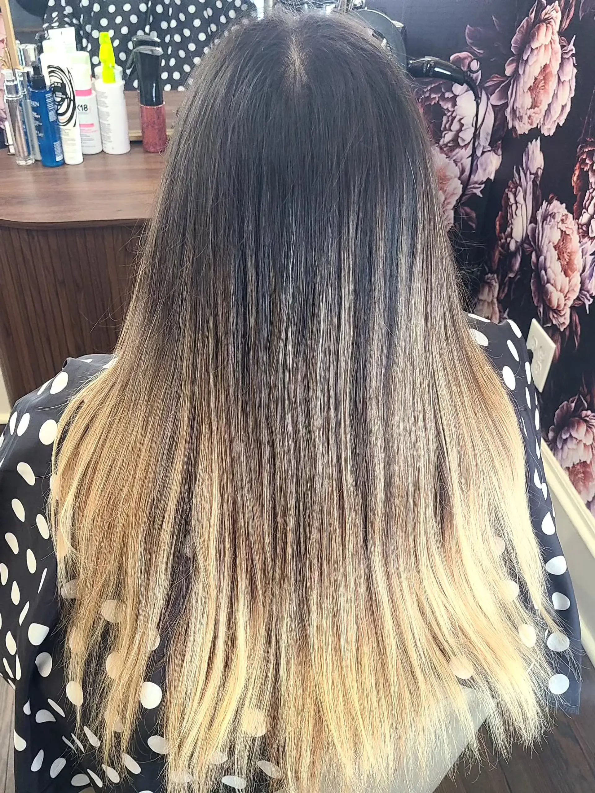 Long, wavy hair with a blended balayage coloring technique that transitions from dark roots to warm caramel and golden blonde ends, styled with soft, loose waves. 5