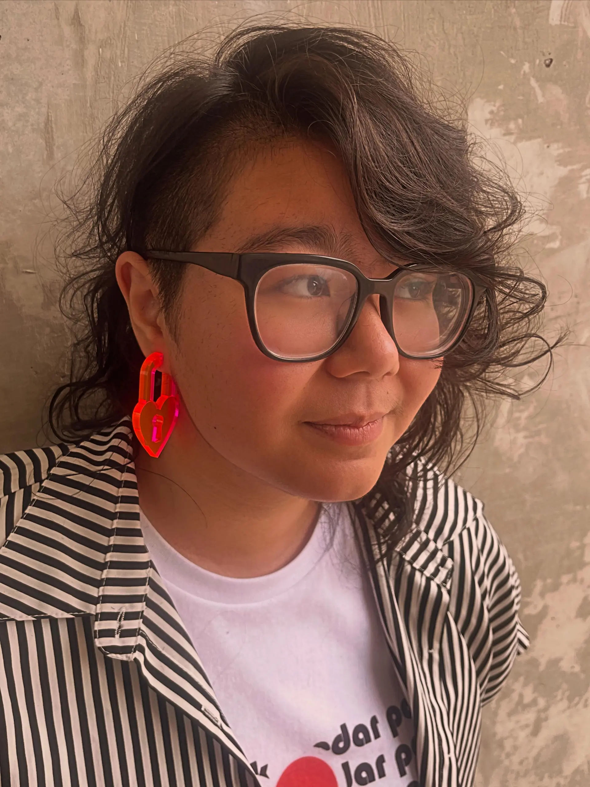 An edgy disconnected haircut featuring a closely cropped undercut on the side with textured, tousled dark waves on top. 1