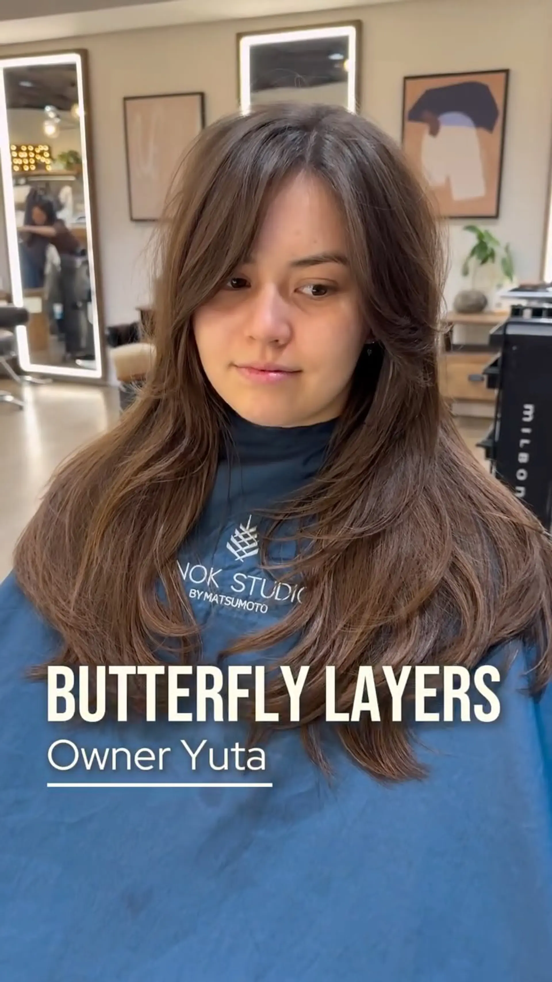 Long brunette butterfly haircut featuring face-framing curtain layers and soft, feathered texture. 1