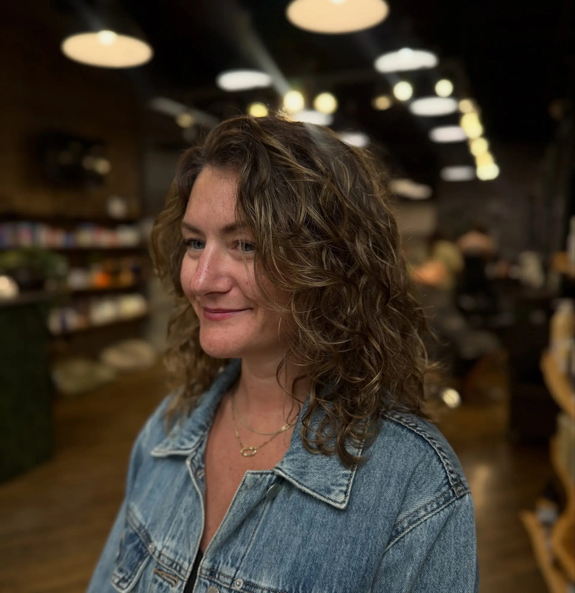 Shoulder-length layered curly hairstyle with natural volume and defined curl texture. 1