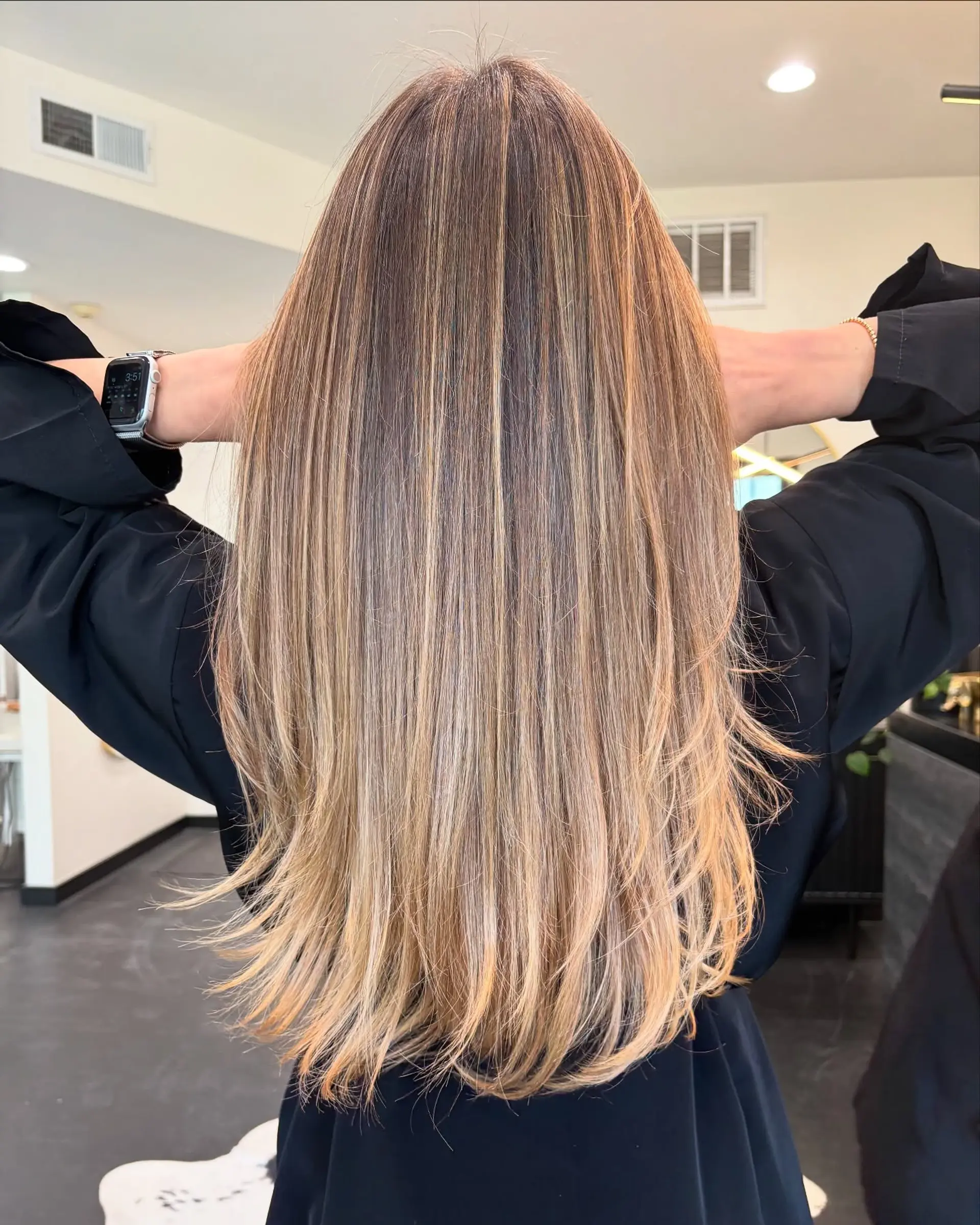 Long, sleek straight hair featuring soft, seamlessly blended caramel and honey blonde balayage highlights over a natural brown base. 1