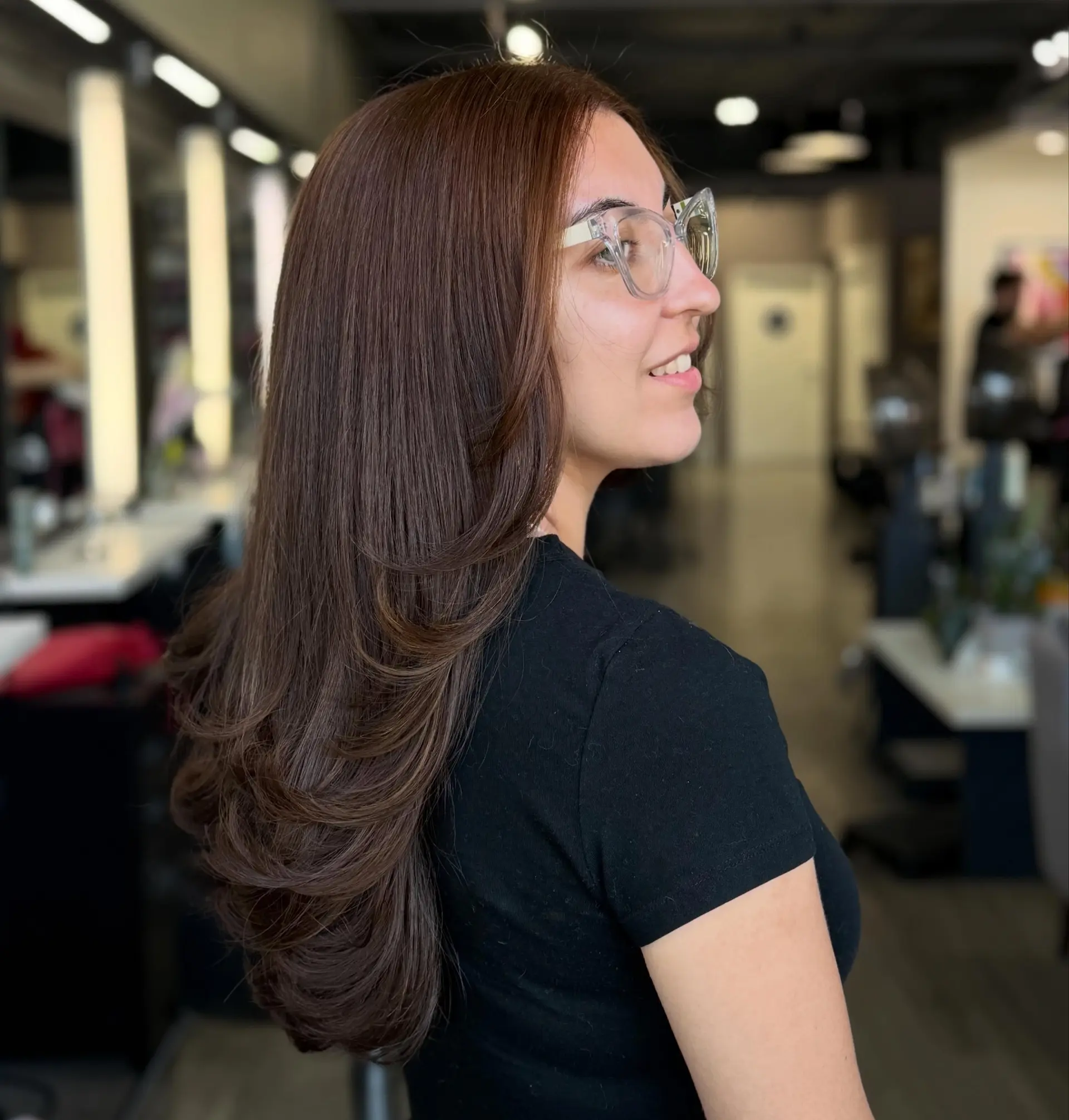 Long chocolate brown hair cut into flowing, cascading layers with smooth, curved ends from a polished blowout. 1