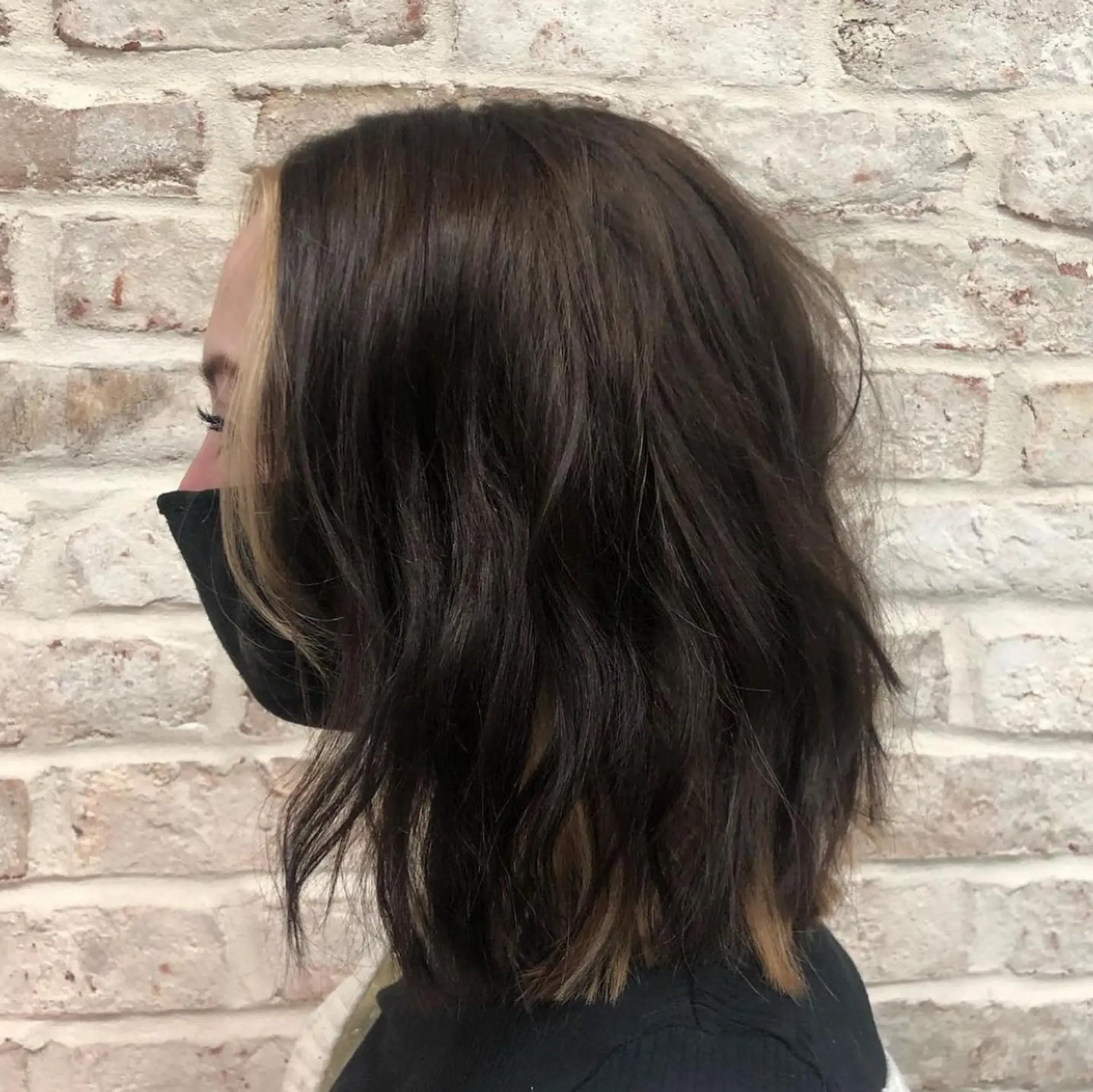 A medium-length textured lob with dark brown waves and contrasting blonde peekaboo highlights along the front and underlayer. 1