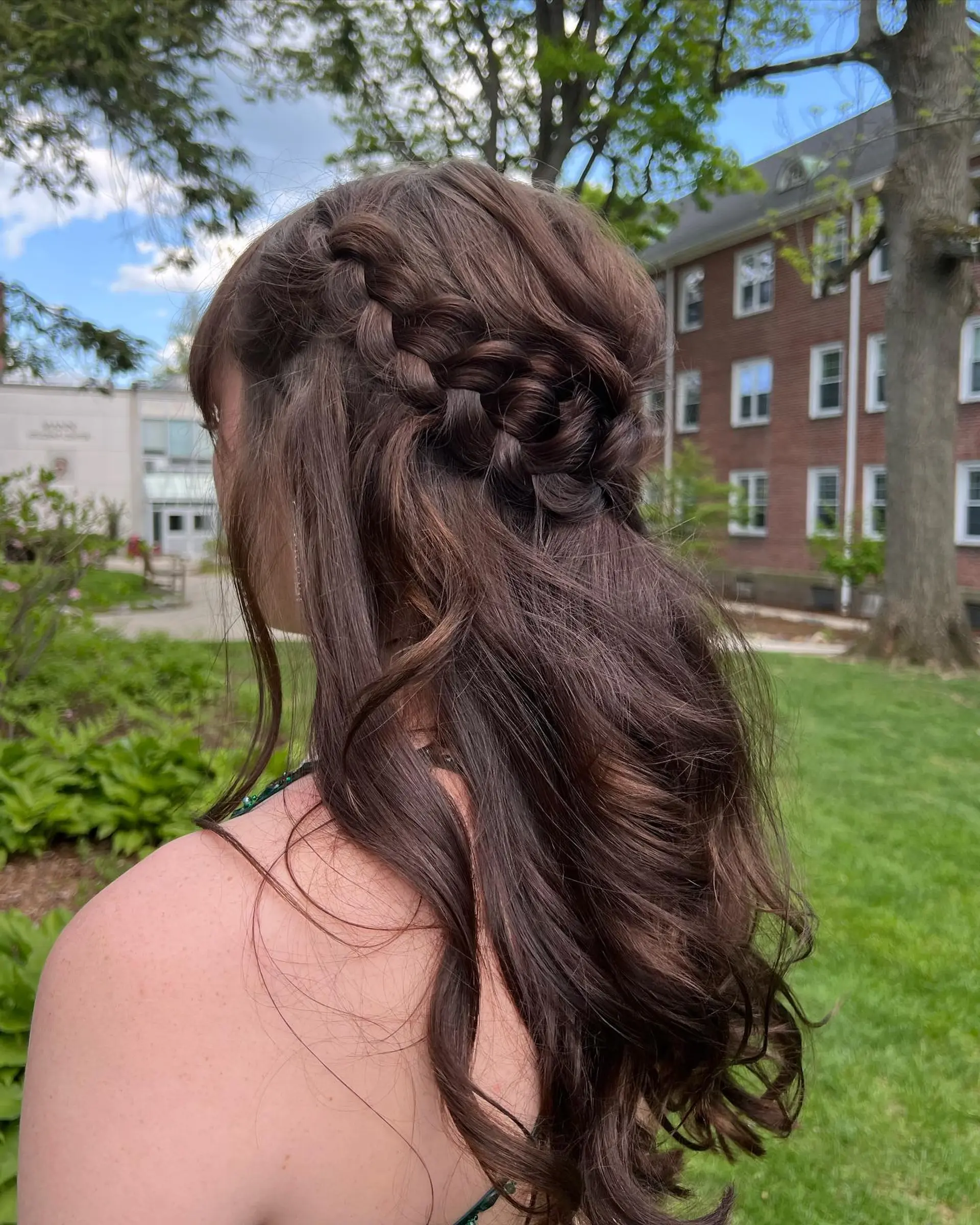 A romantic half-up, half-down hairstyle featuring a thick side Dutch braid wrapping into soft, cascading curls. 1