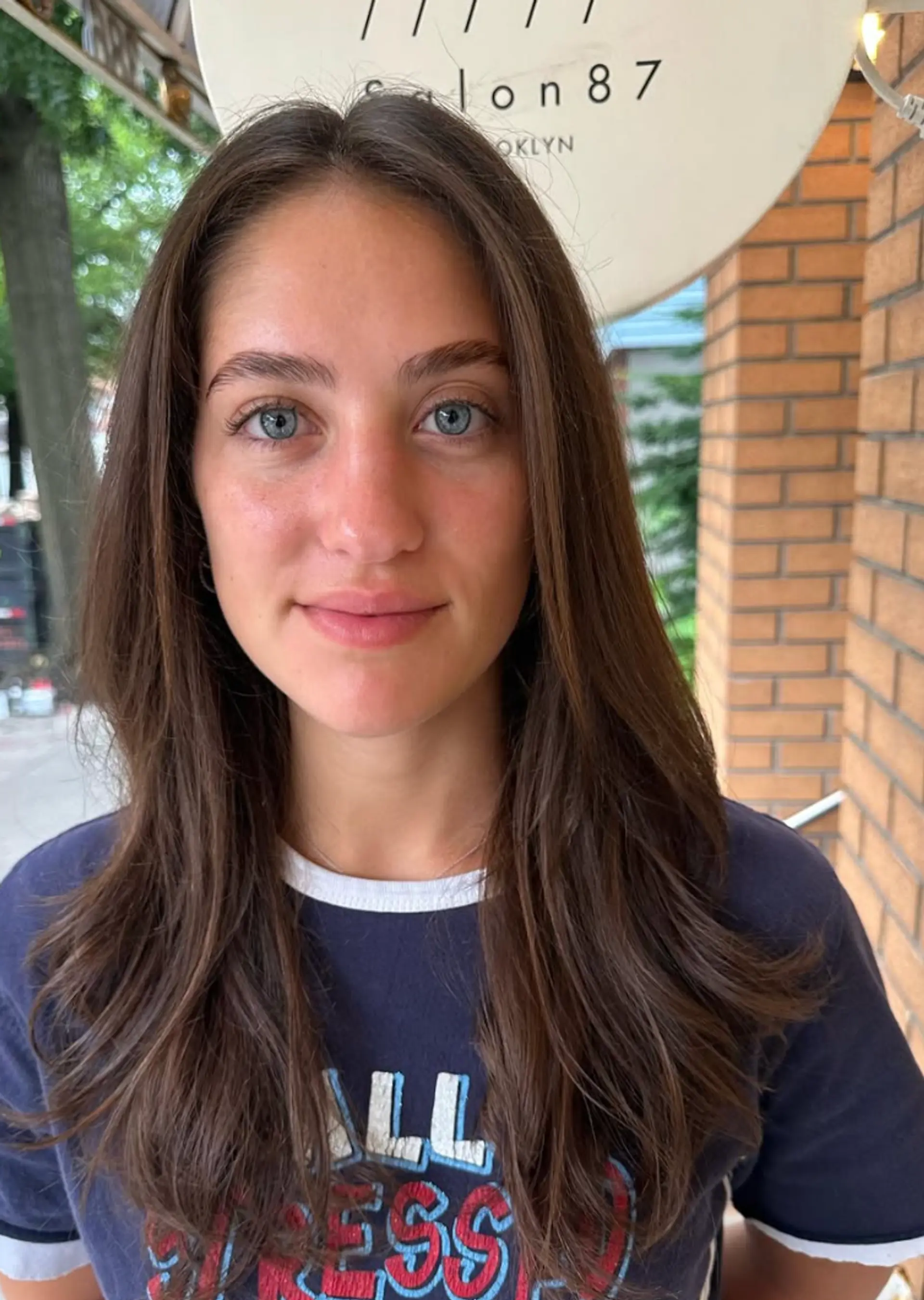 Long, straight, and layered brown hair with a middle part, flowing softly for a natural and casual appearance. 1