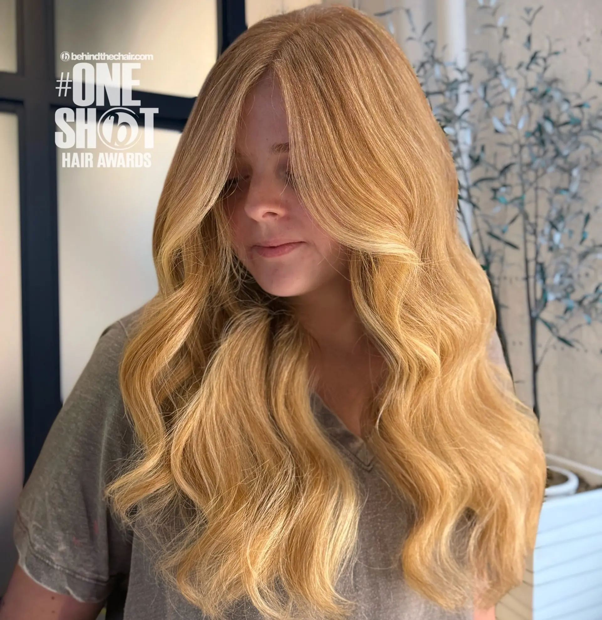 Long strawberry blonde hair styled into soft, beachy waves with long face-framing layers. 1