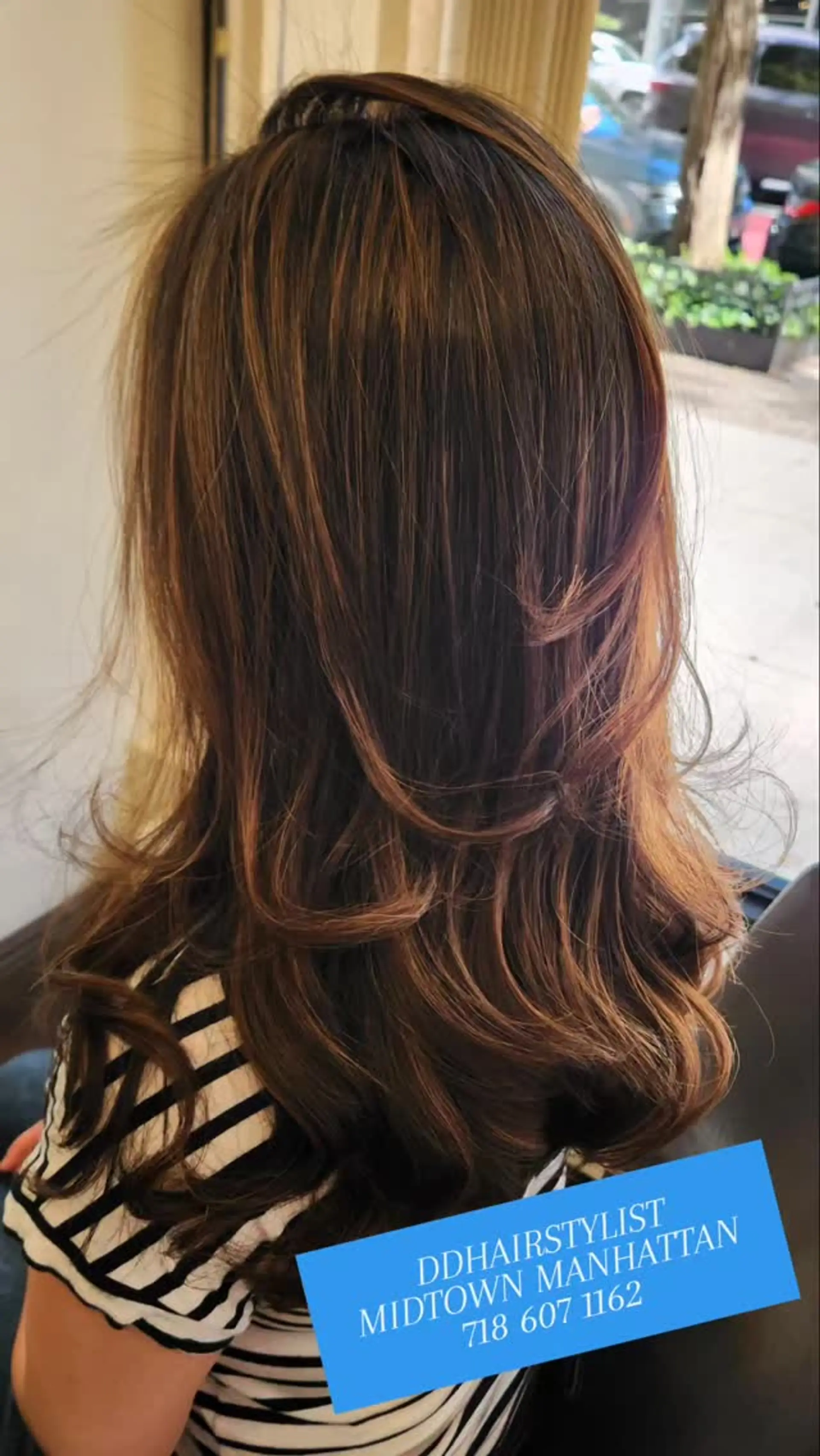 Long layered dark brunette hair enhanced with fine caramel highlights and styled with flipped, bouncy curled ends. 1