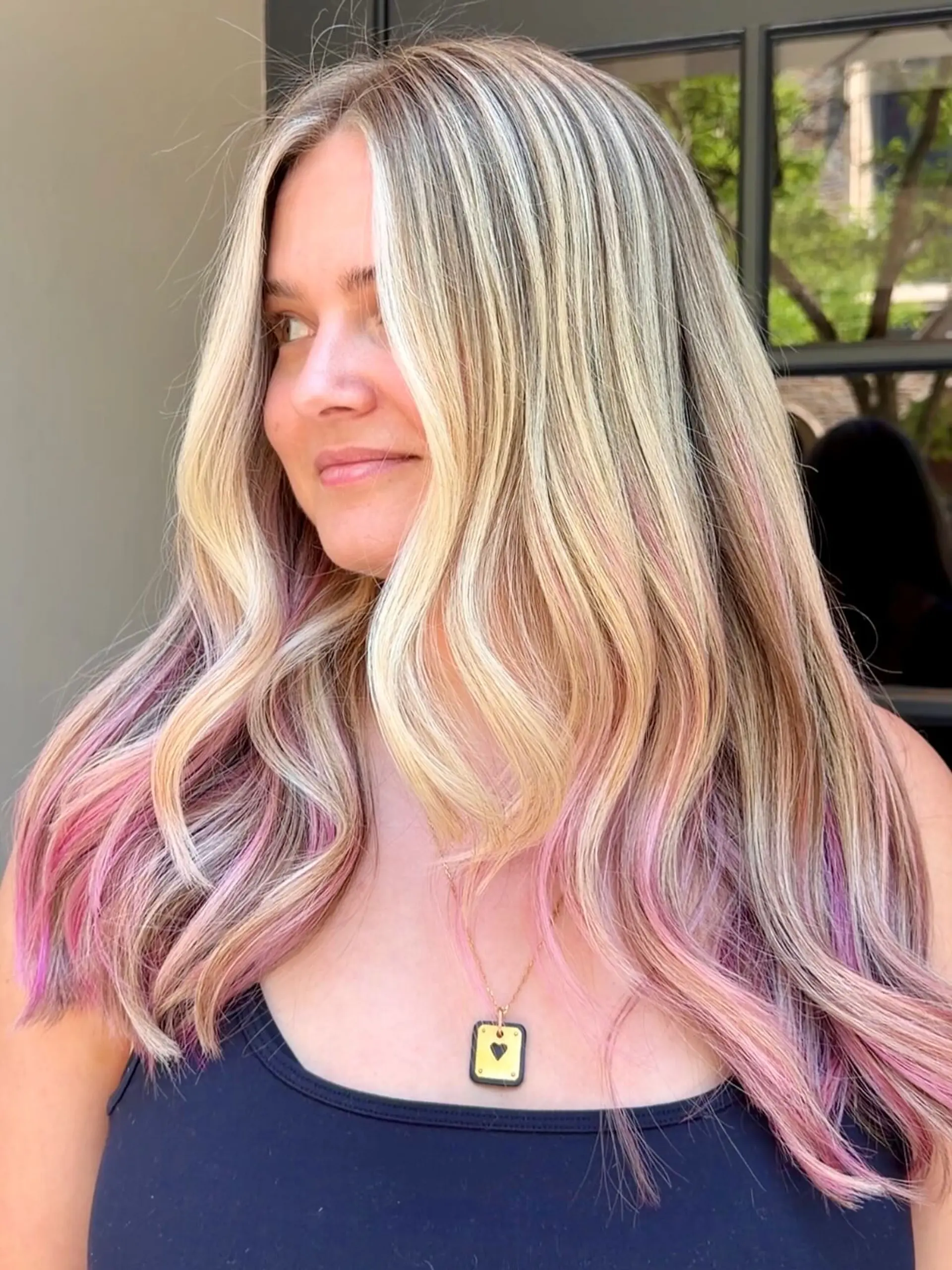 Long wavy highlighted blonde hair featuring vibrant pink peekaboo lowlights and bright face-framing strands. 1