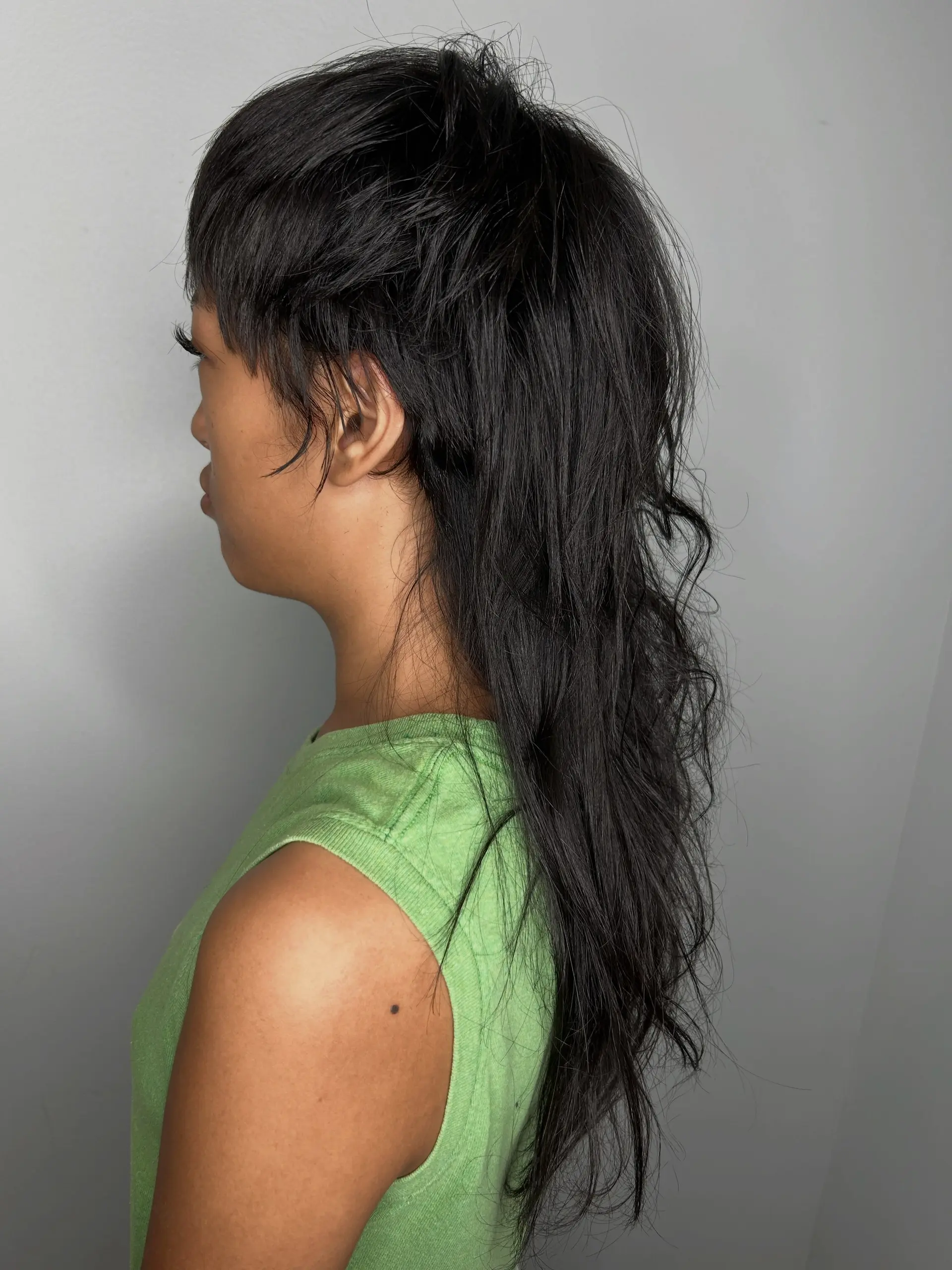 A modern mullet featuring textured, cropped layers through the crown and front paired with long, piecey lengths cascading down the back. 1
