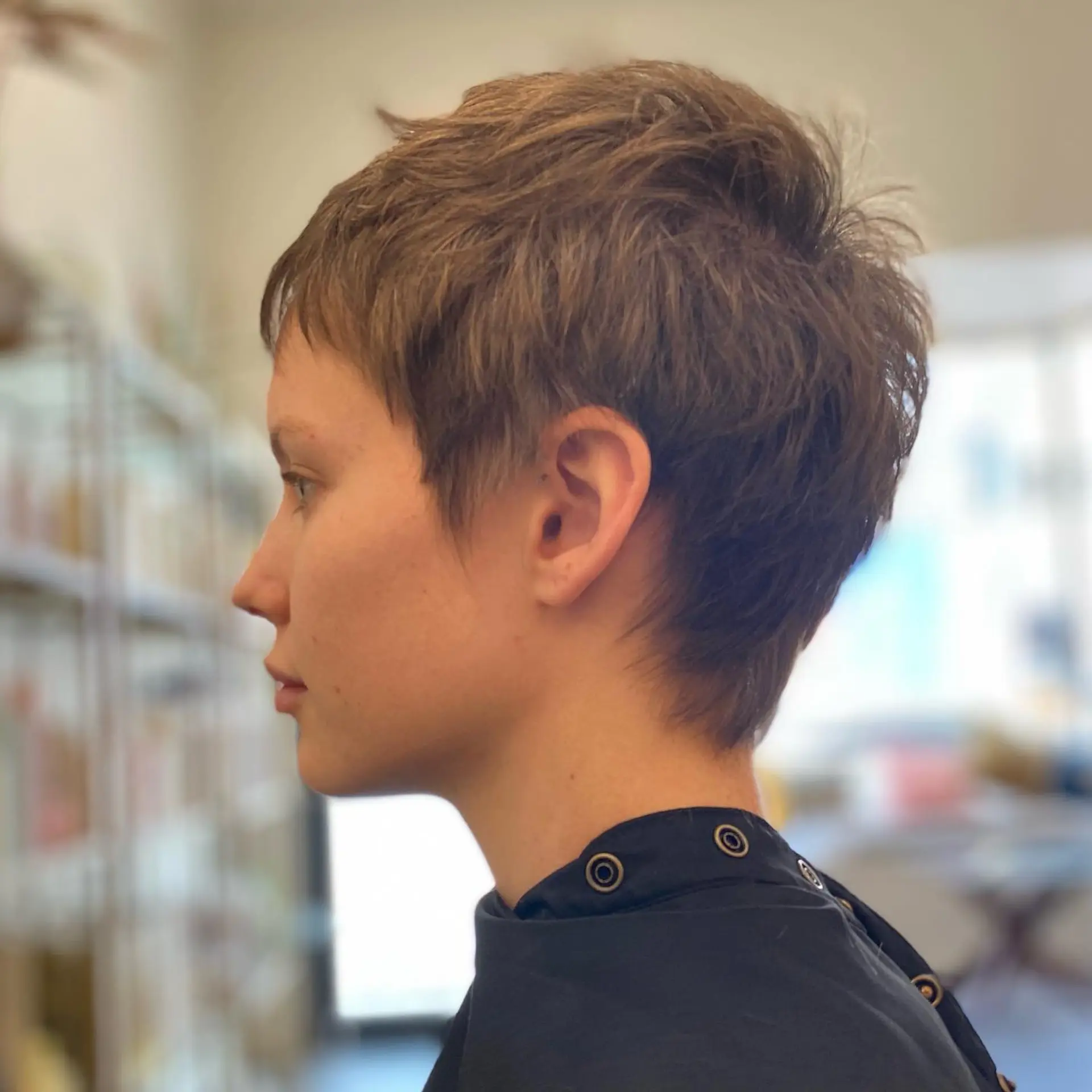 A textured, layered pixie cut with soft micro-bangs and tapered sides. 1