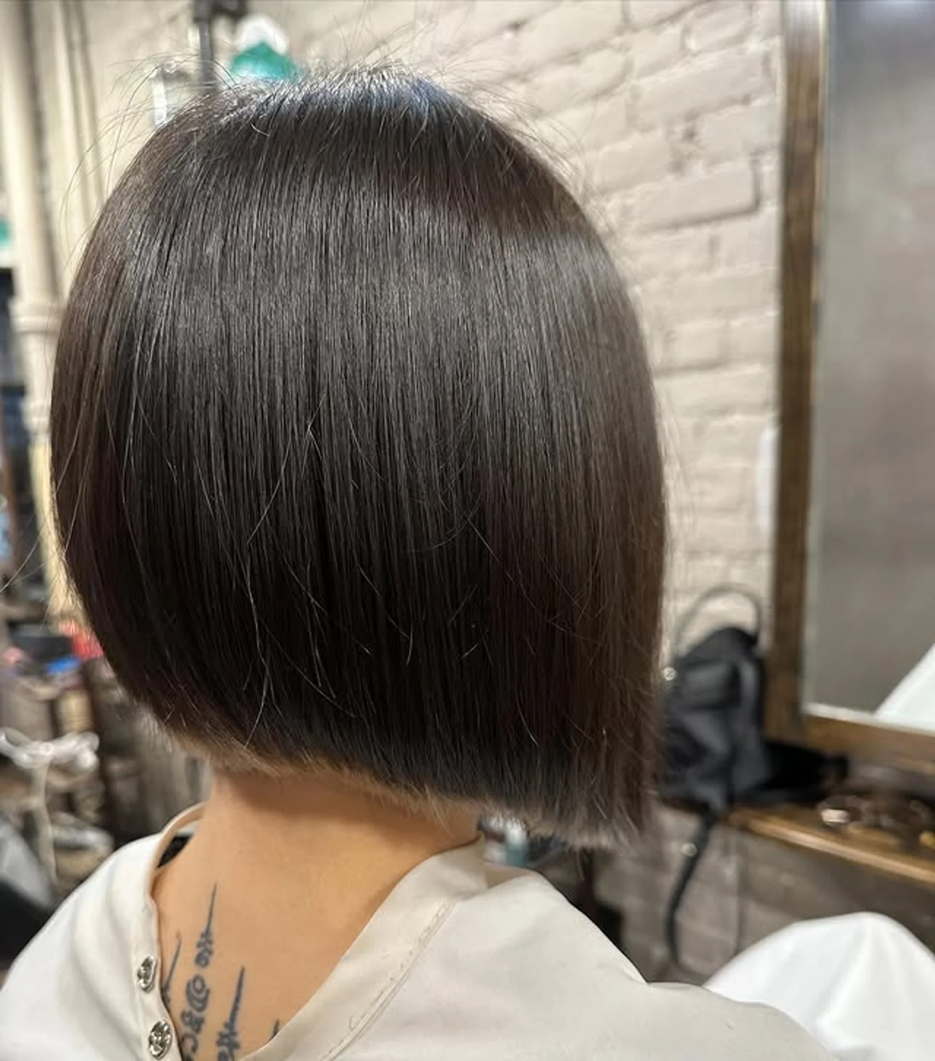 Sleek modern asymmetrical bob haircut with precise lines, embodying a contemporary trend. - Preview 1