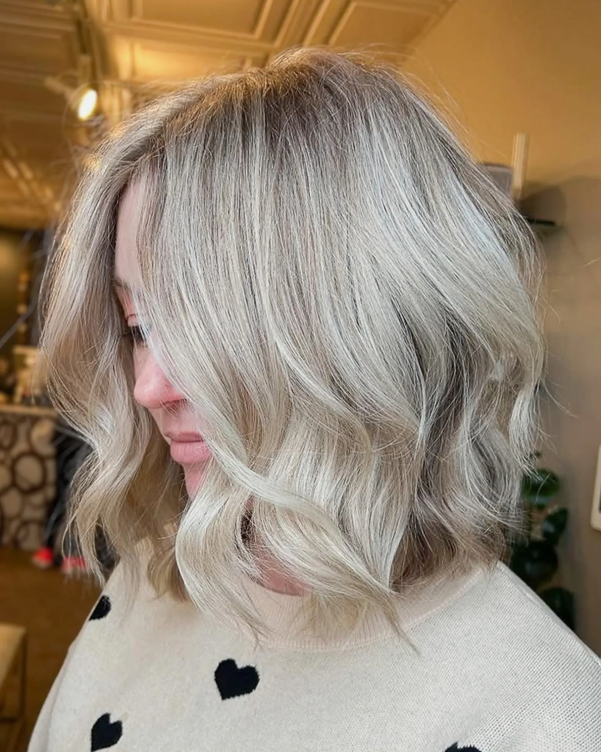 A dimensional cool blonde bob cut to the collarbone and styled in loose, textured waves. 1