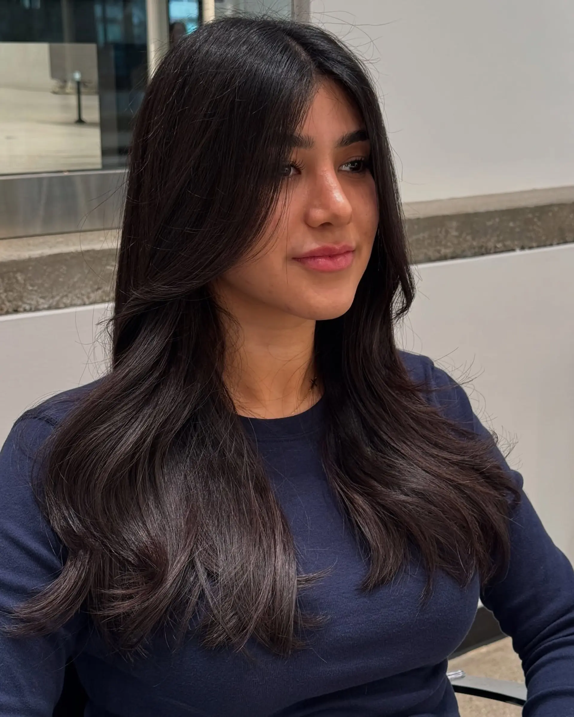 A layered haircut with face-framing curtain bangs and long layers for added movement. 2