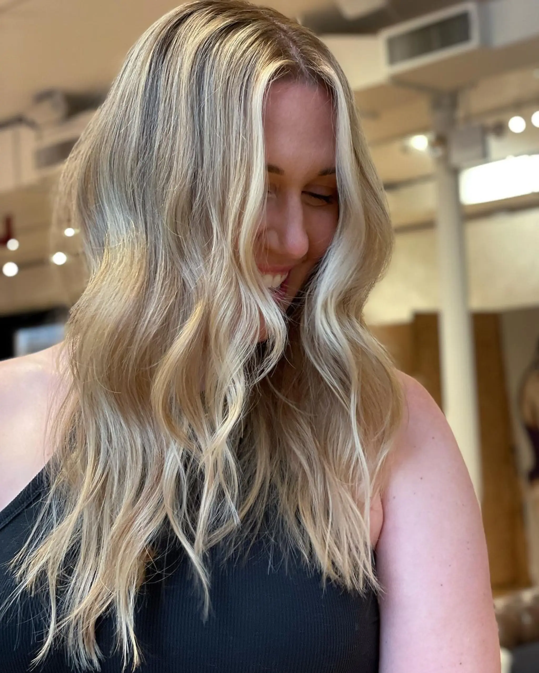 Long wavy hair with honey blonde and golden hues, creating natural, beach-like waves and a sun-kissed look.