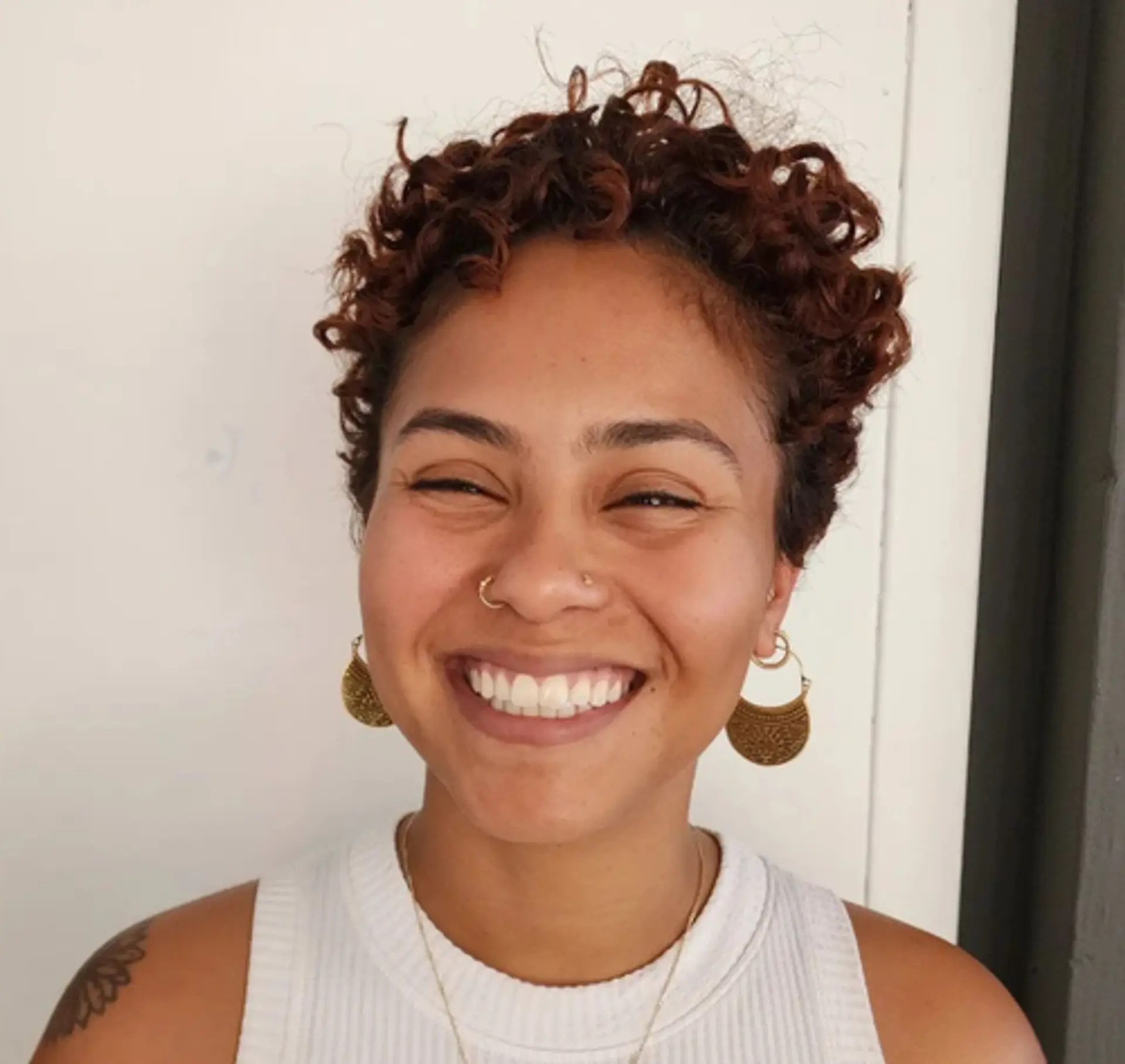 Short, light brown curly hair with natural texture and voluminous curls. 1