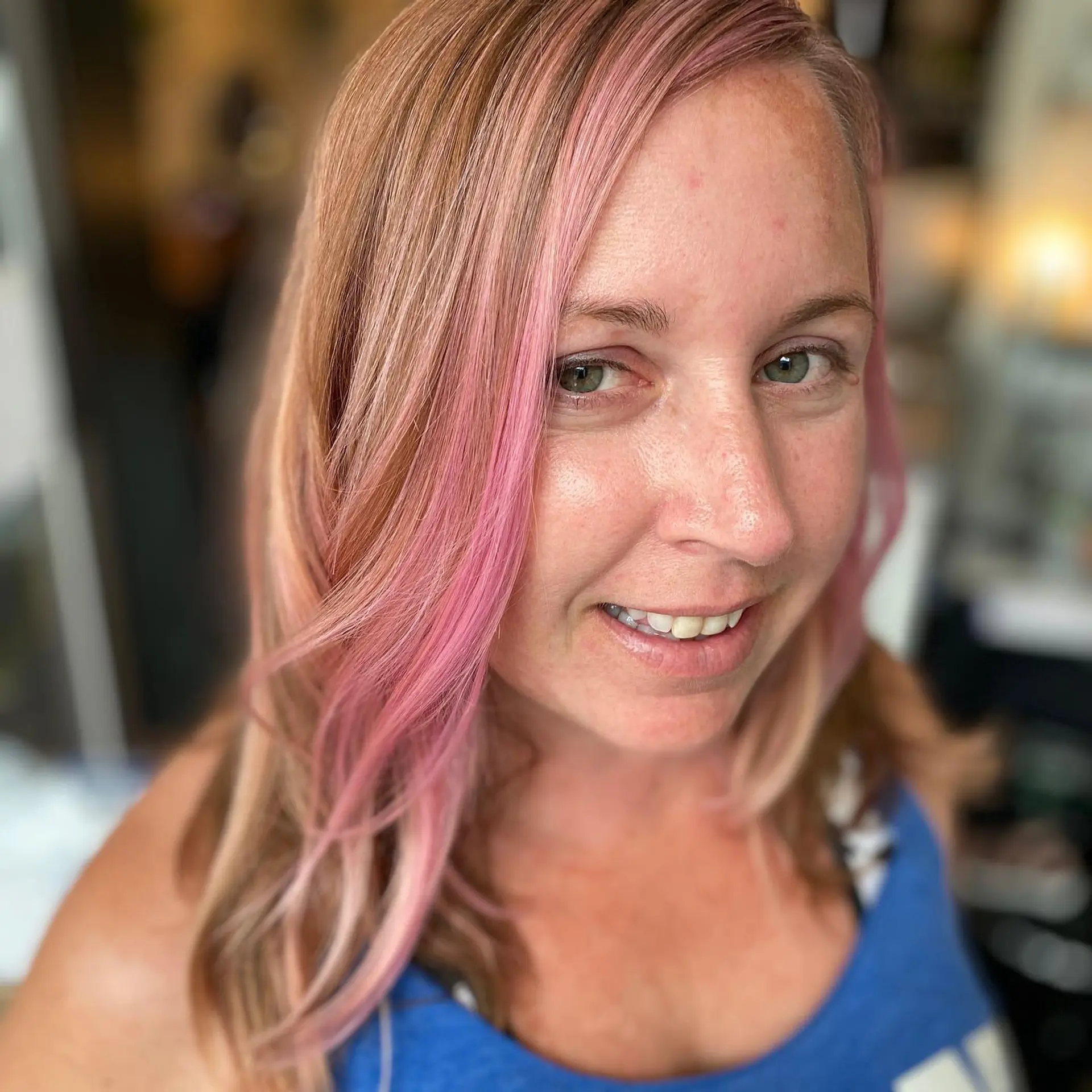 Medium-length blonde hair enhanced with vibrant pastel rose pink face-framing streaks and subtle highlights. 1