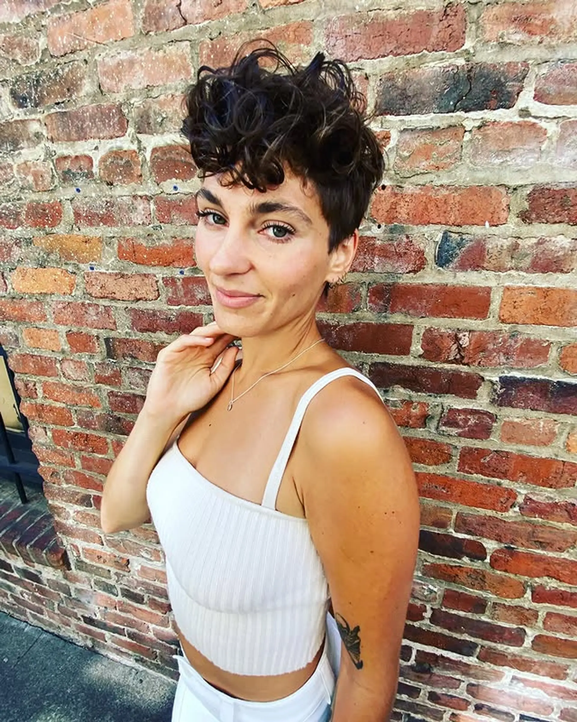 A short, curly pixie cut with a textured finish. 1