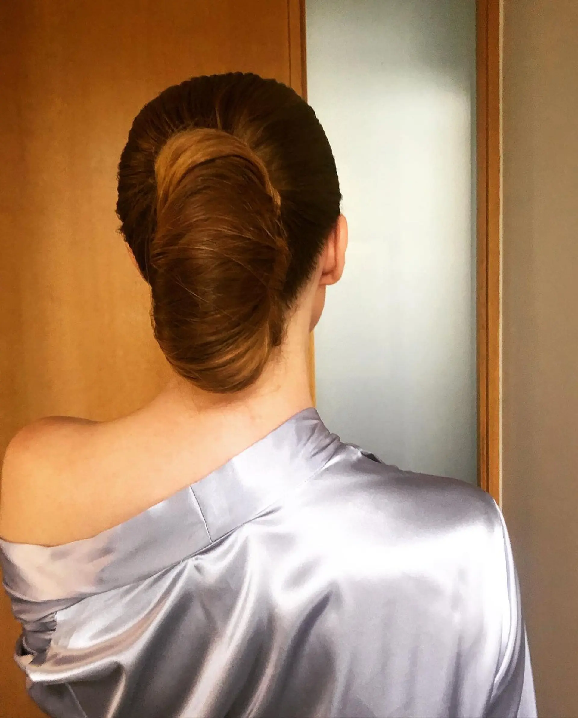 An elegant chignon with straight, long light brown hair styled into a low, polished bun. 3