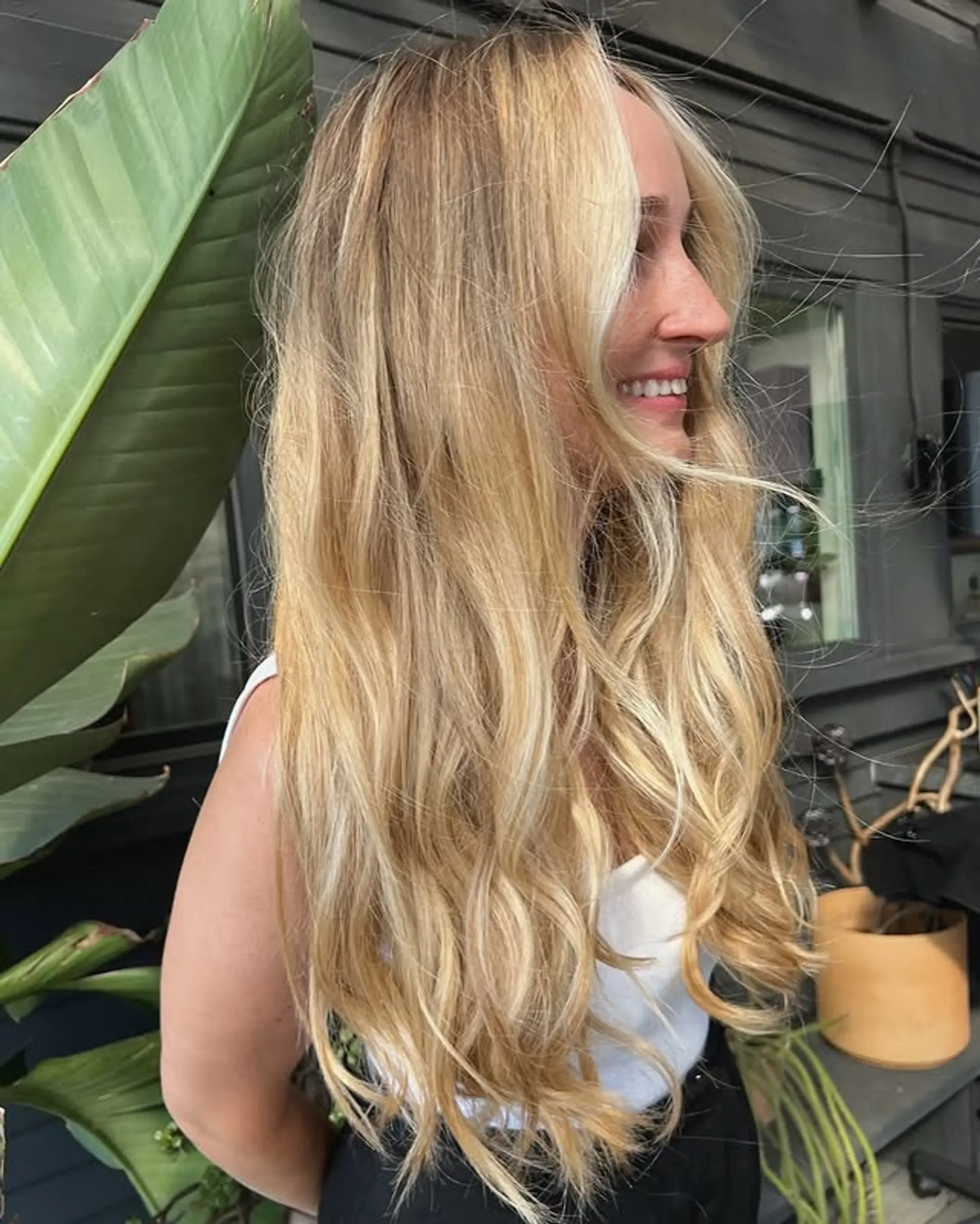 A long, wavy blonde balayage with face-framing layers. 1