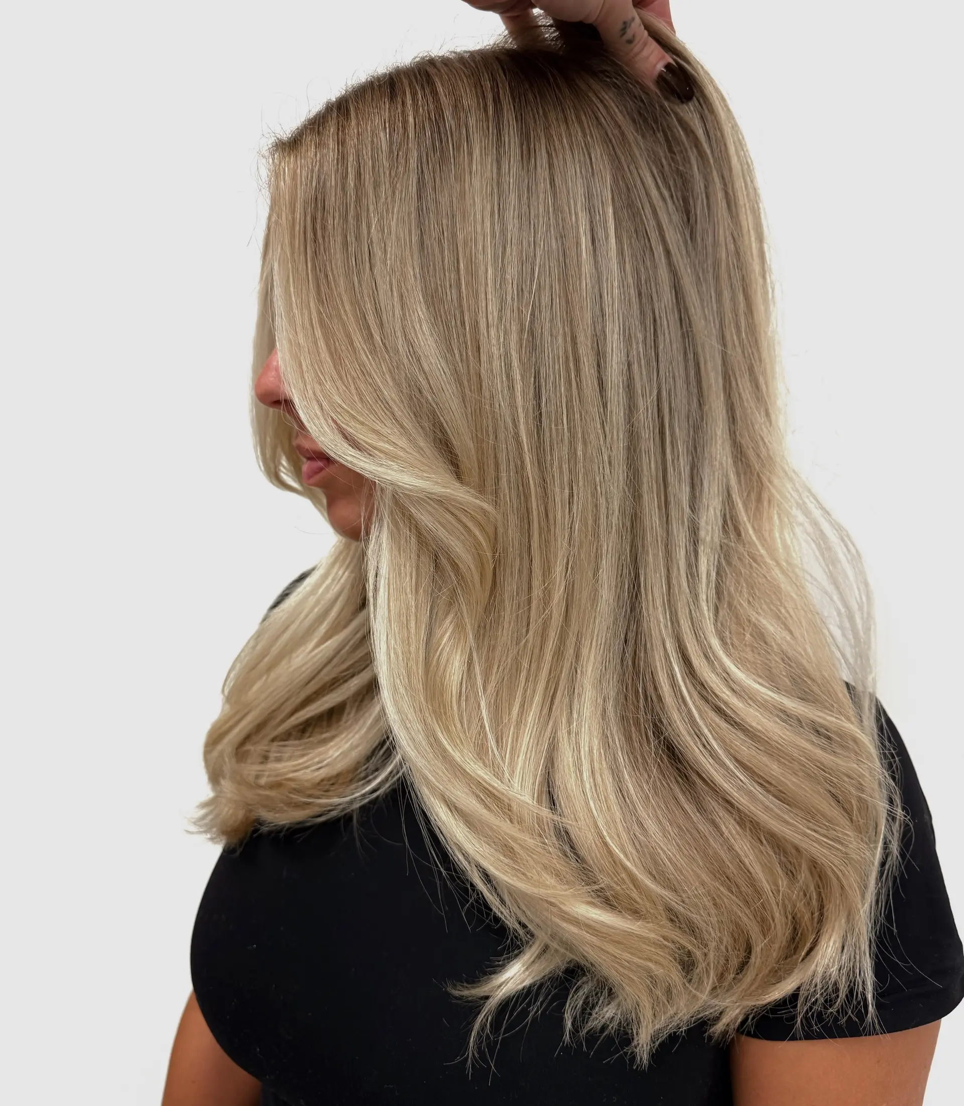 Long dimensional ash blonde hair styled in a smooth blowout with soft, voluminous curled ends. 1