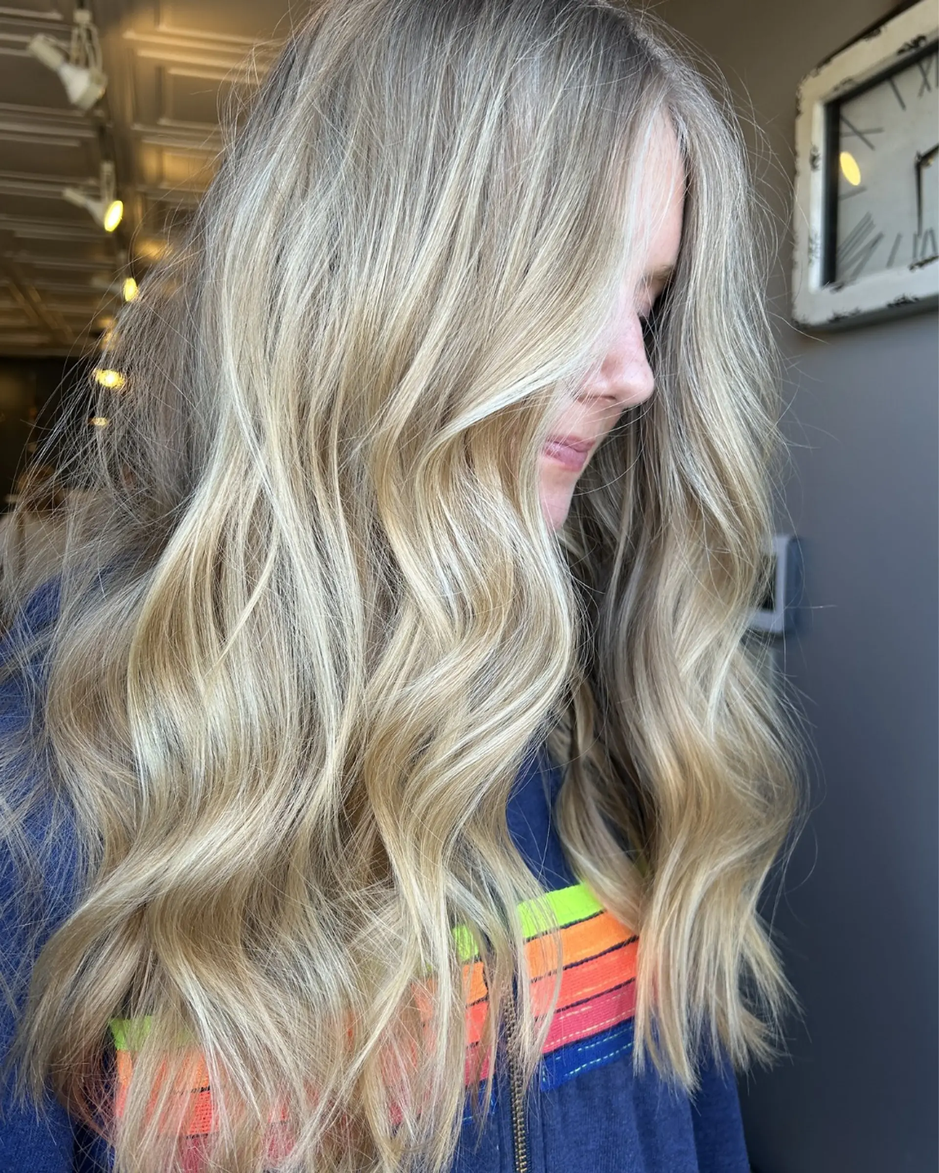 Long dimensional blonde hair featuring bright, face-framing highlights and soft, loose beach waves. 1